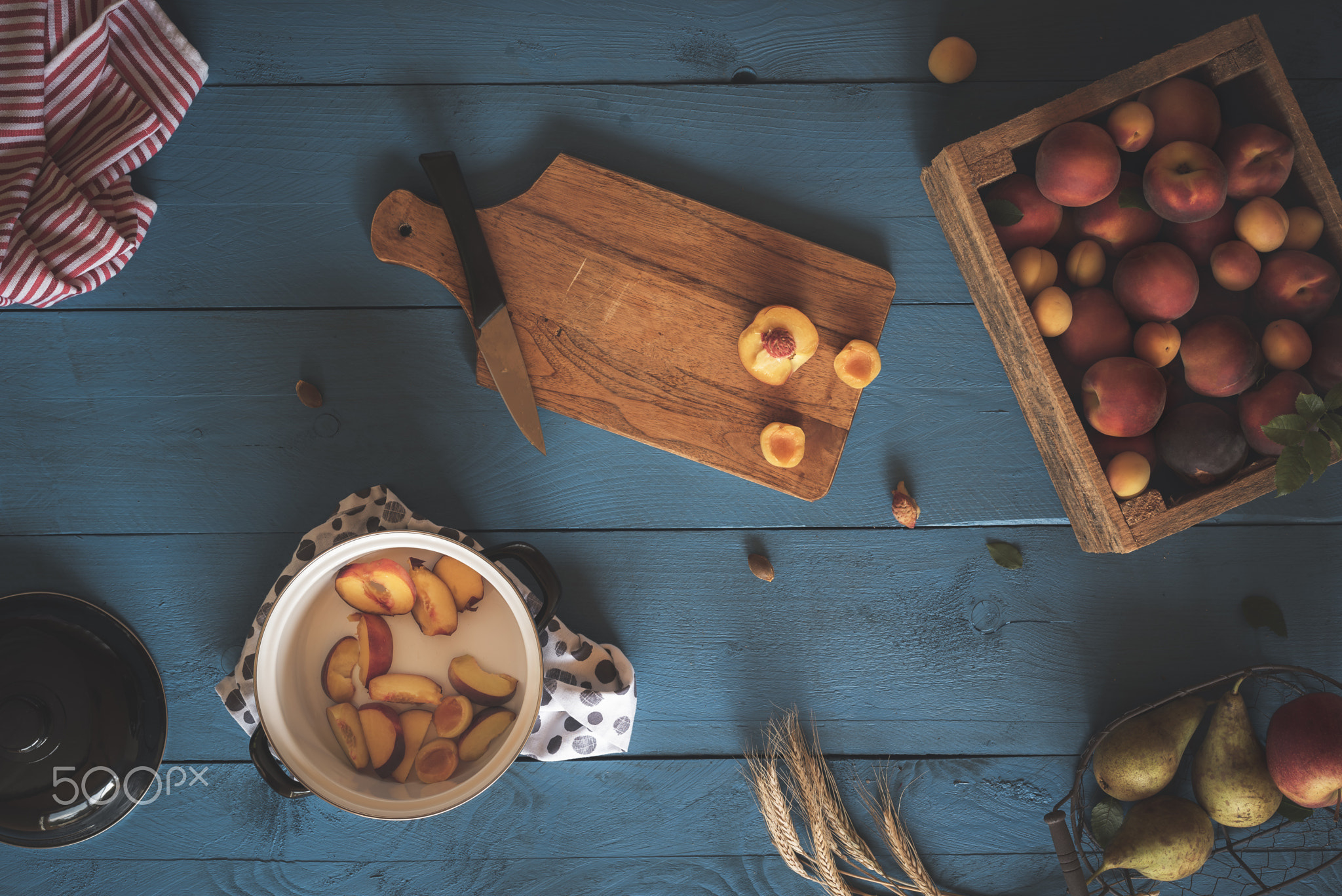 Pot with peach slices and fresh fruits in box. Jam making