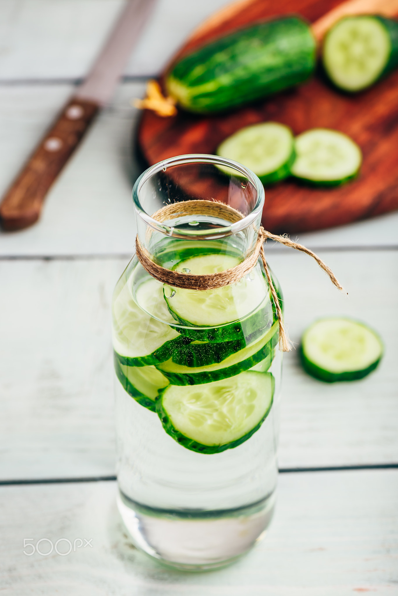 Infused water with sliced cucumber in bottle