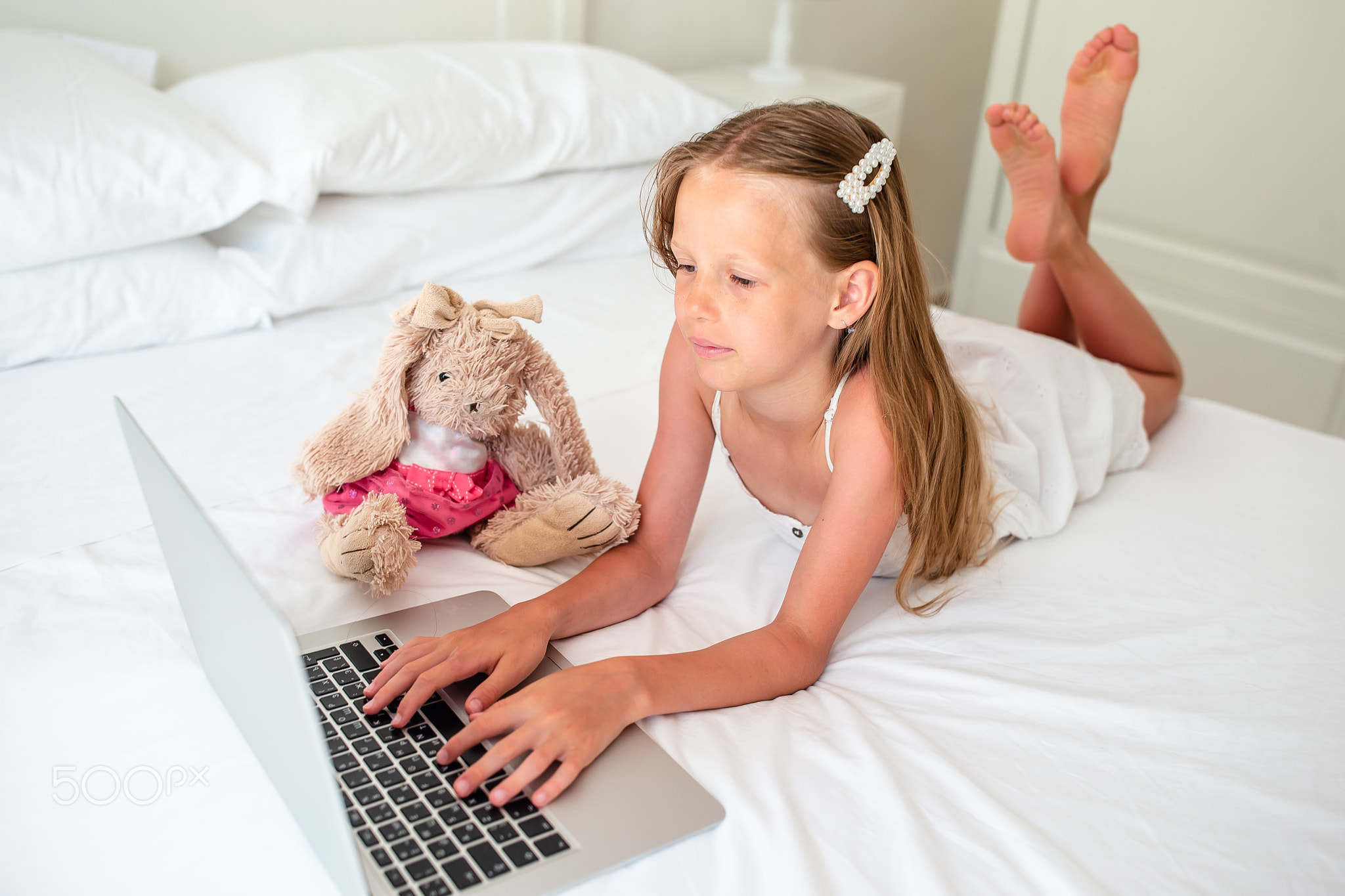 Cute little girl doing homework on laptop