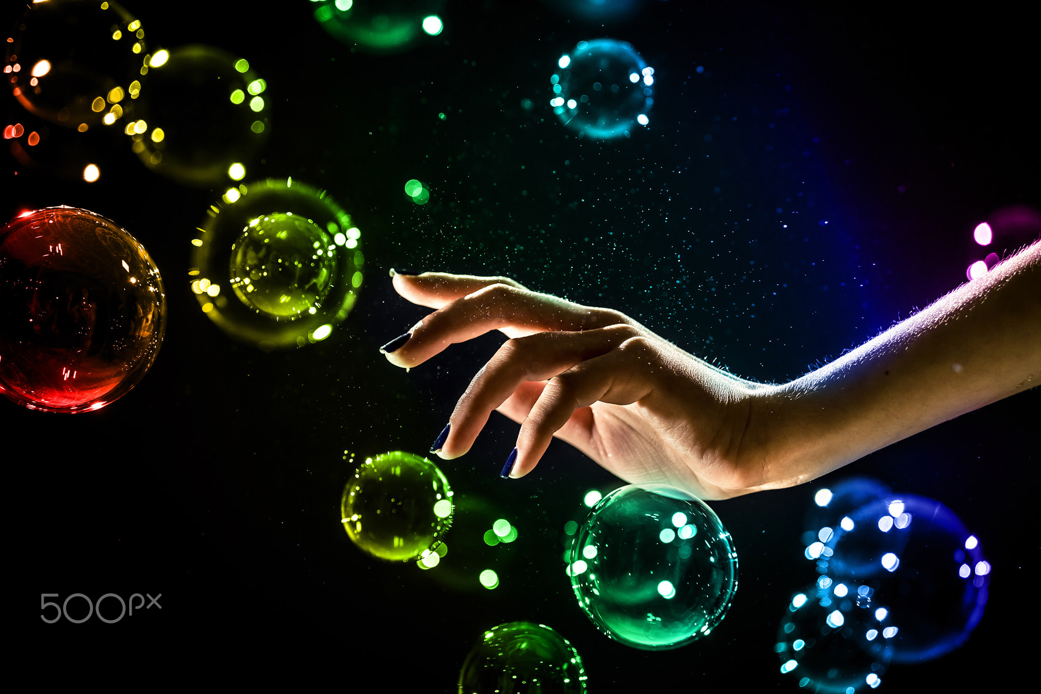 The transparent, iridescent soap bubbles isolated on black.