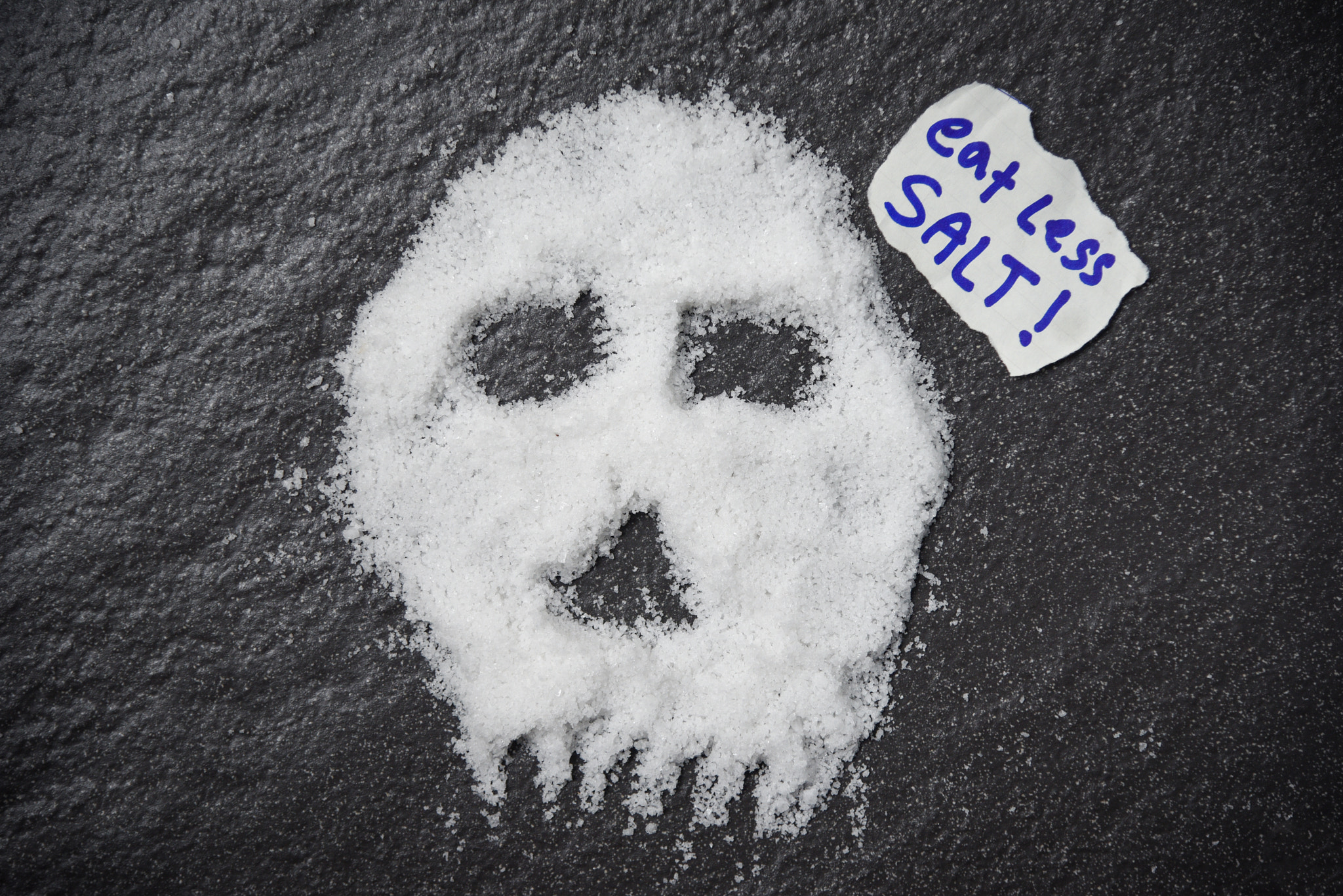 Eat less salt for health concept / Heap of white salt skull shap