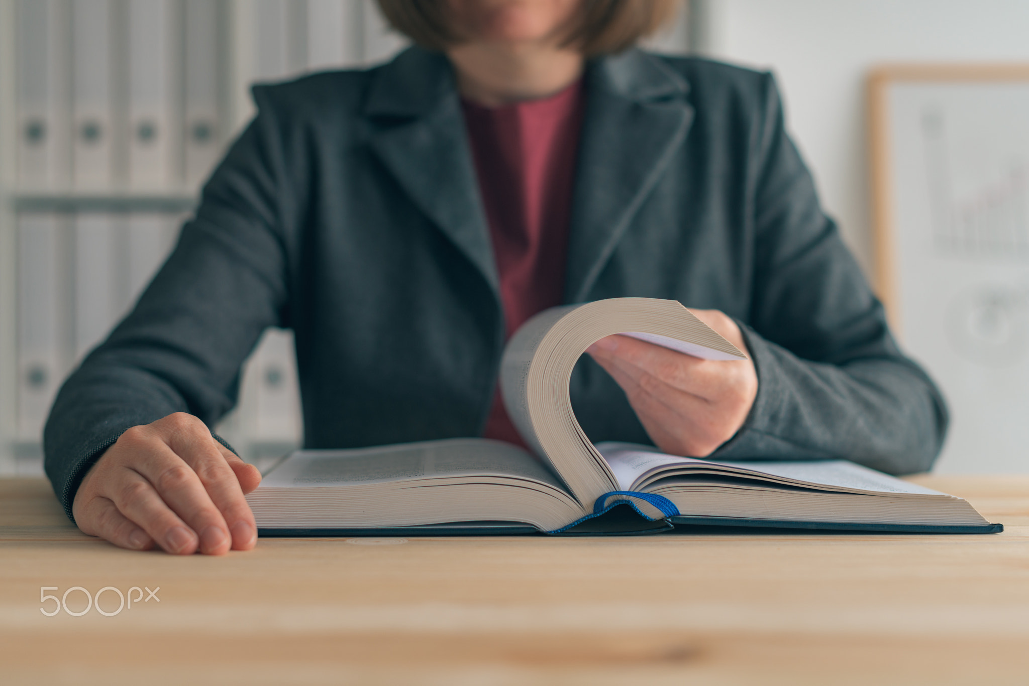 Businesswoman reading book at office desk