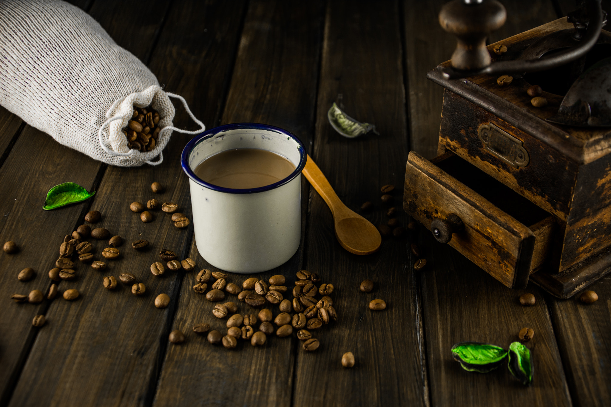 The Coffee. An old coffee grinder with coffee grain on a wood surface