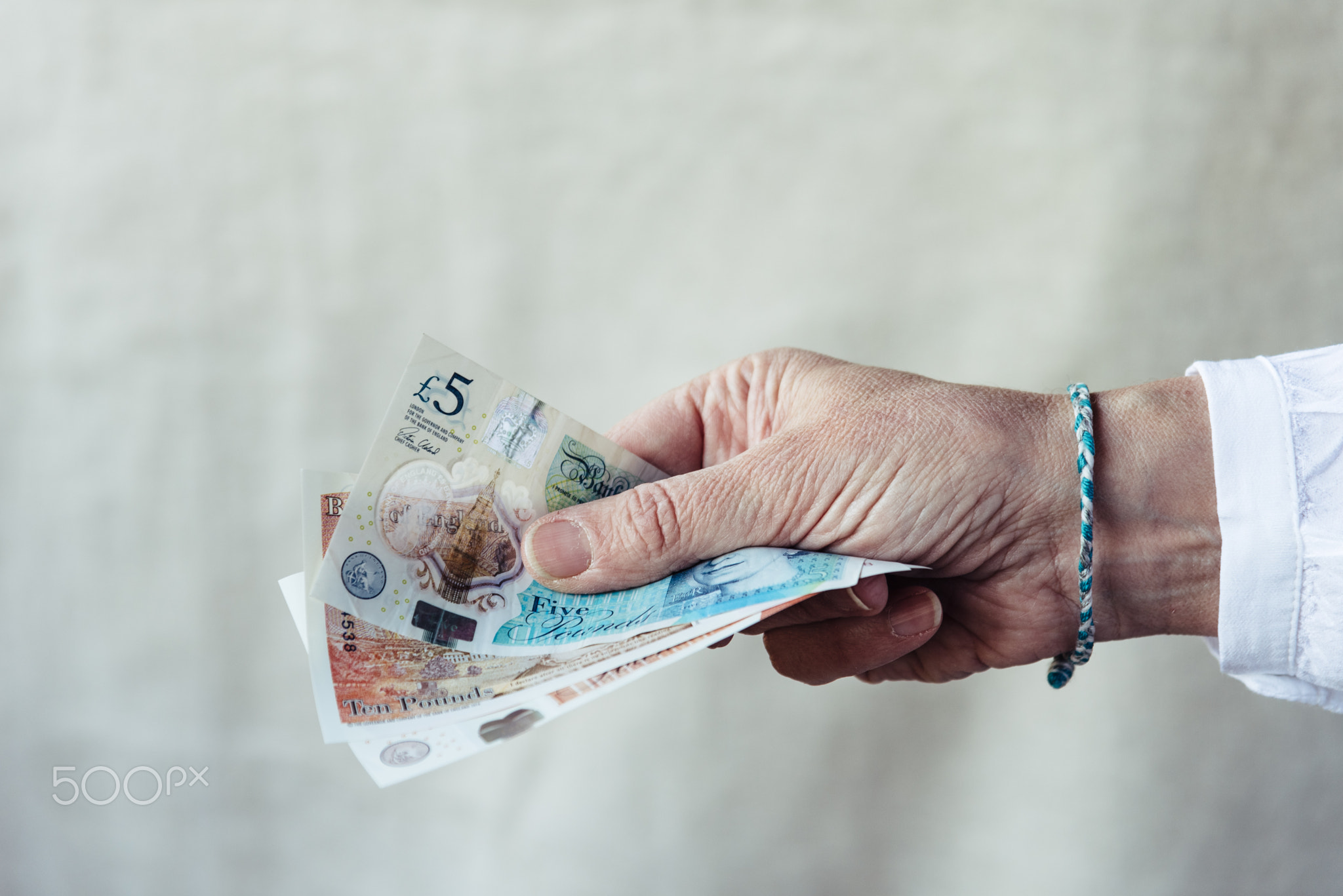 Woman holding pounds sterlings against background