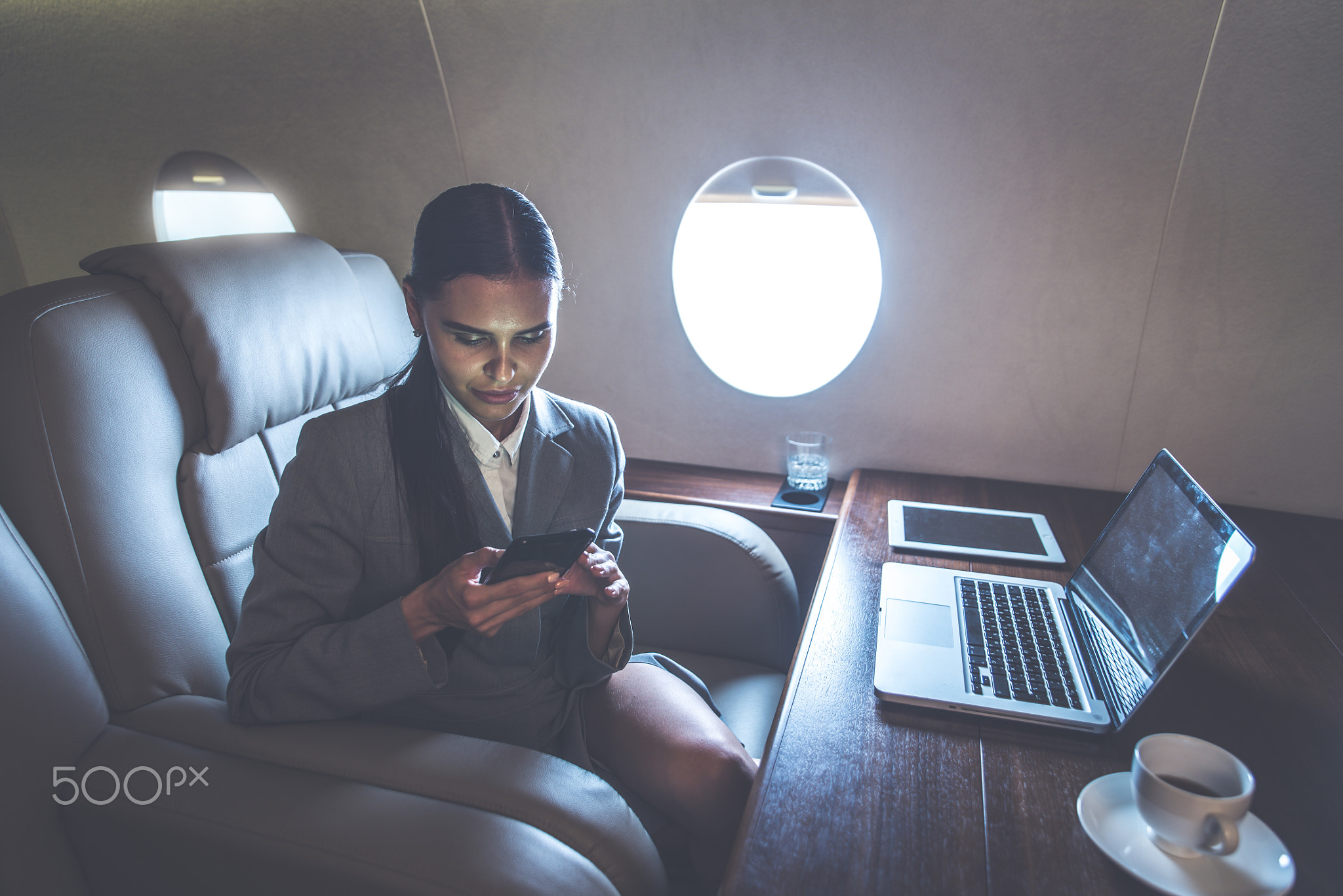 Business woman traveling and working on the private jet