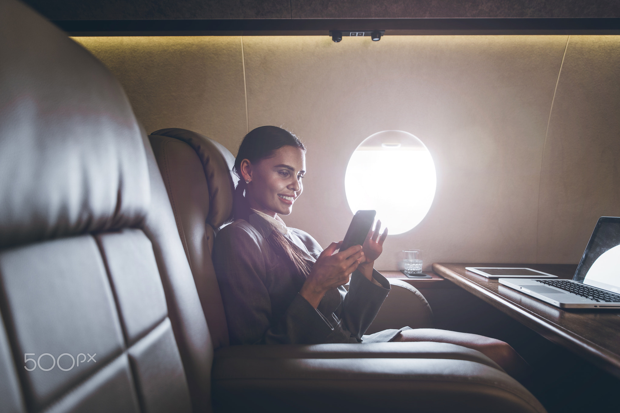 Business woman traveling and working on the private jet