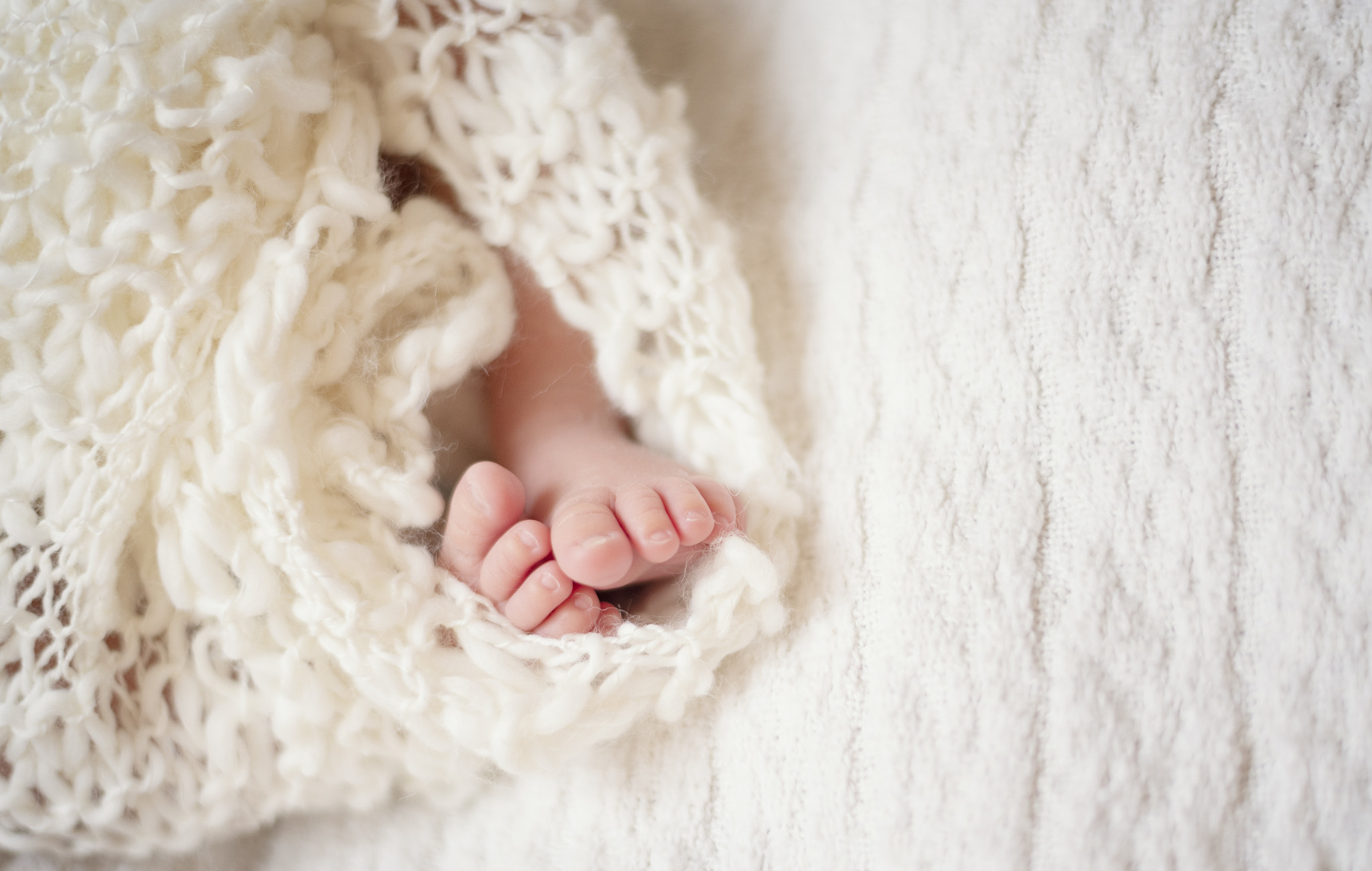 Newborn Baby Feet. Newborn Child. Baby Legs In Knitted Blanket. Beige Nude Background