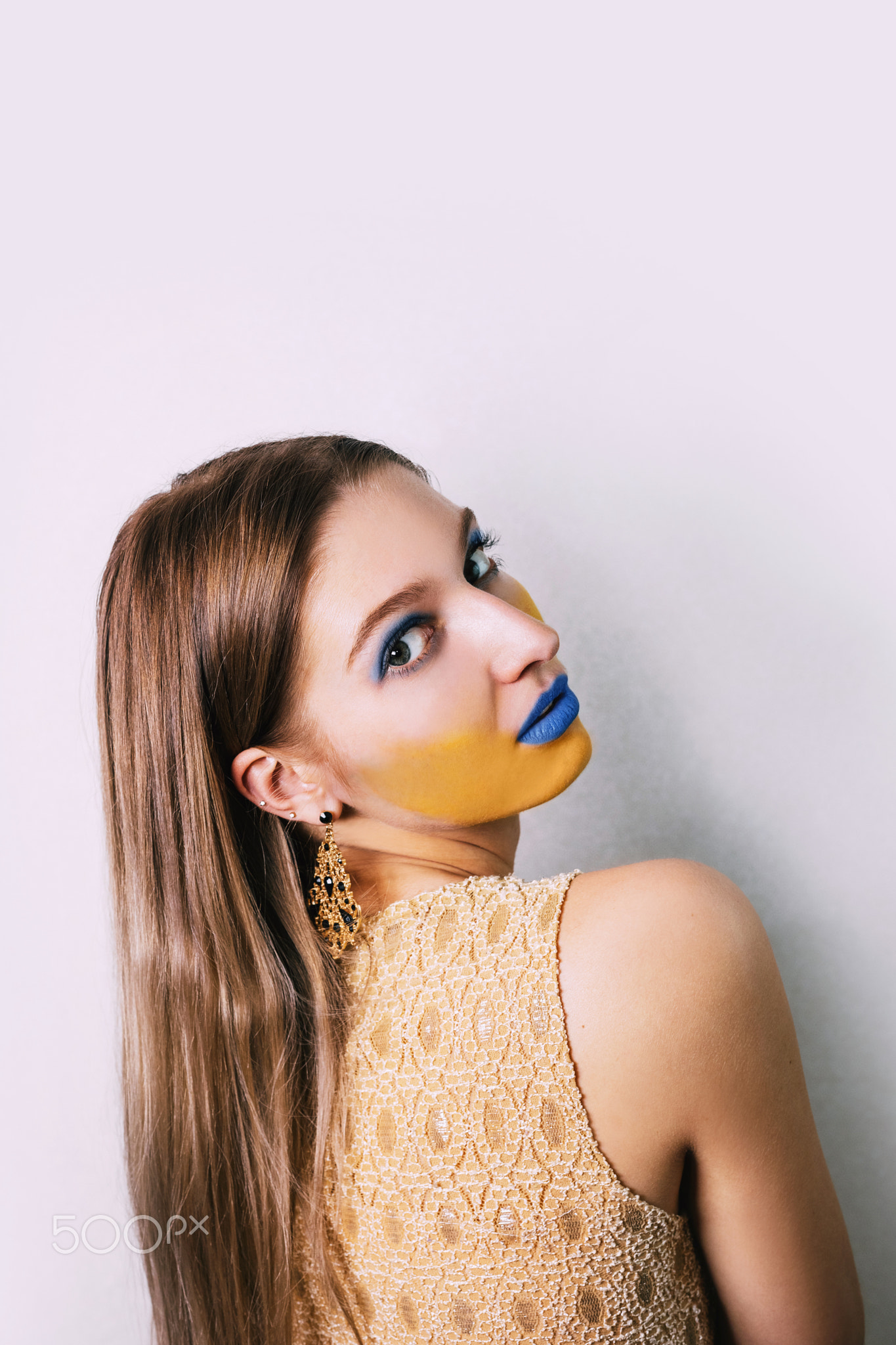 Girl looks over shoulder; yellow/blue face KMphoto