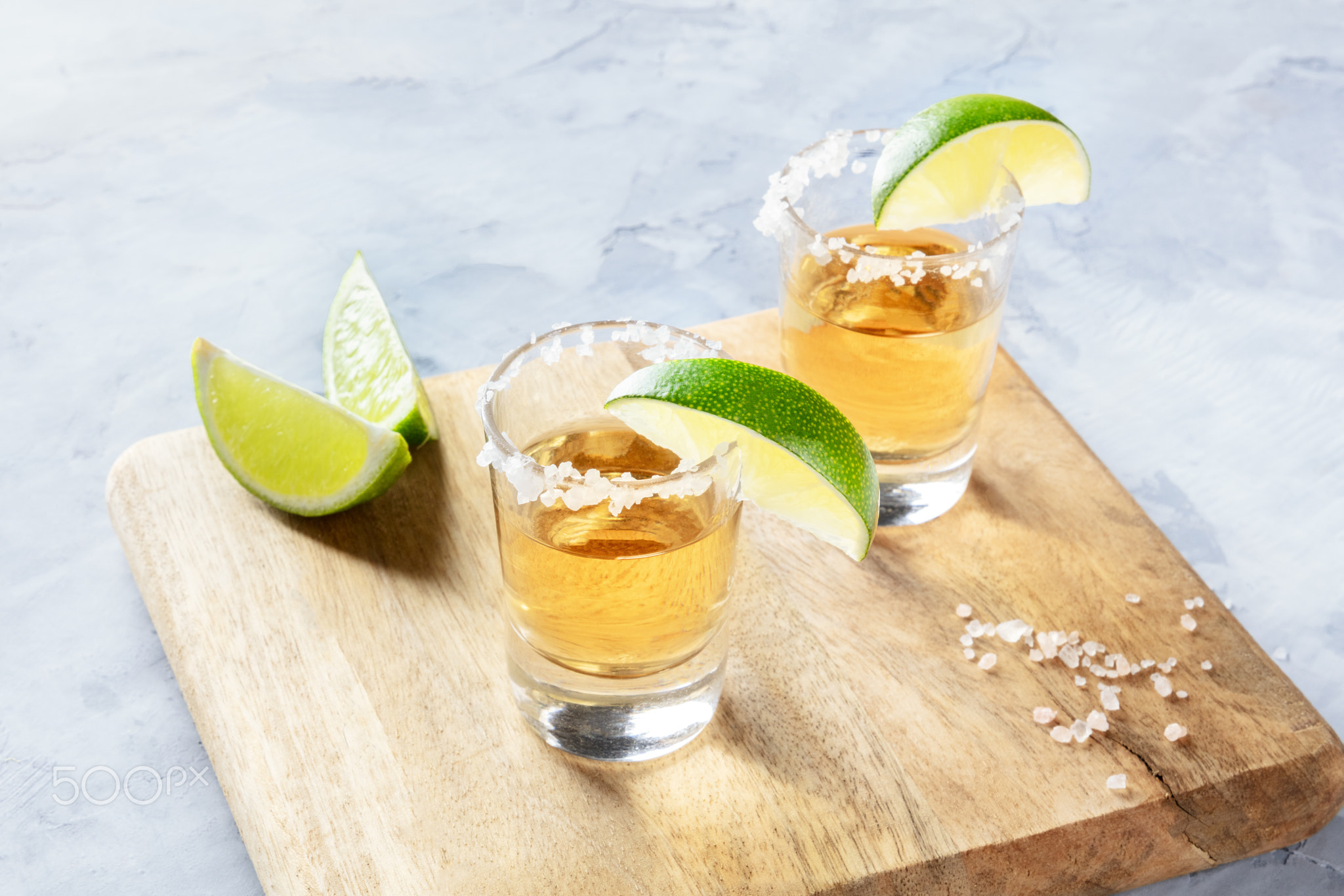 Golden tequila shots with lime slices and salt, with a place for text