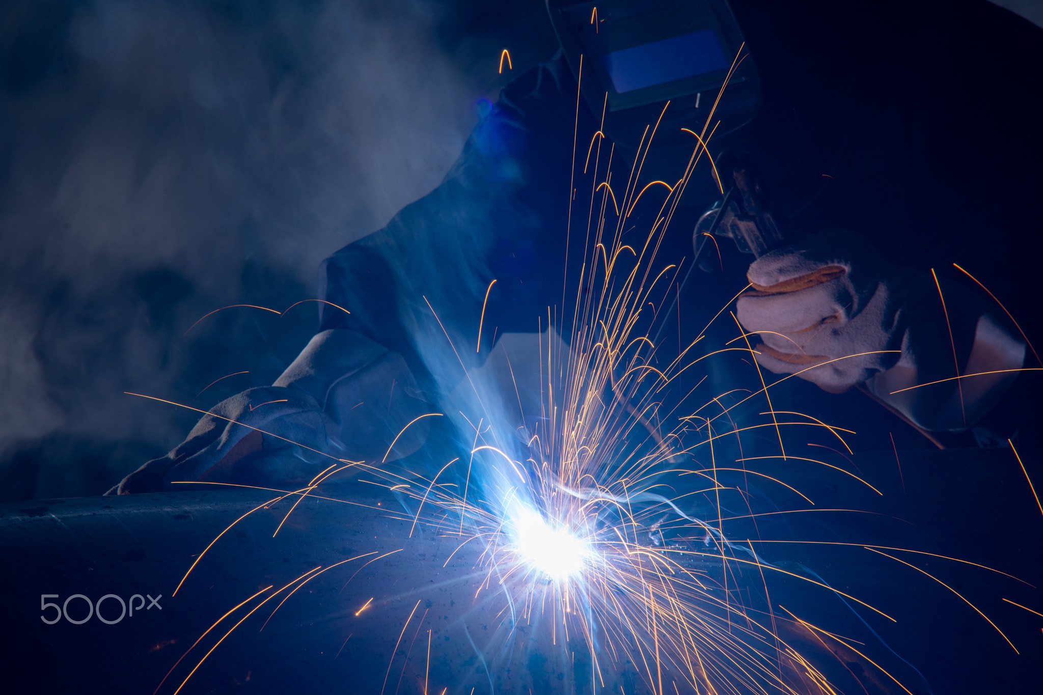 Professional welder and mask welding metal pipe.