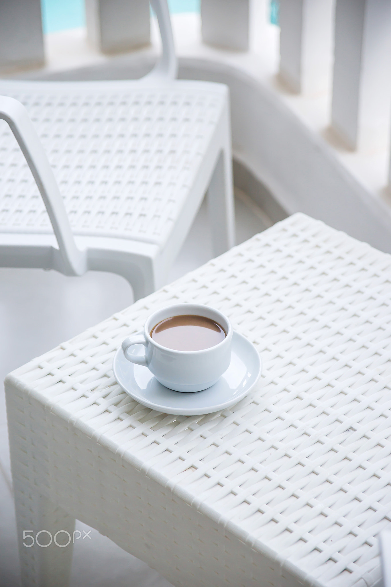 Coffee with milk in a white cup on the balcony of the hotel. The
