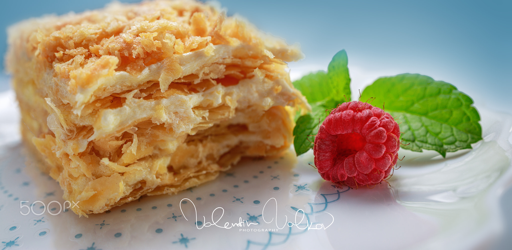 Napoleon cake with vanilla milk cream on a plate isolated