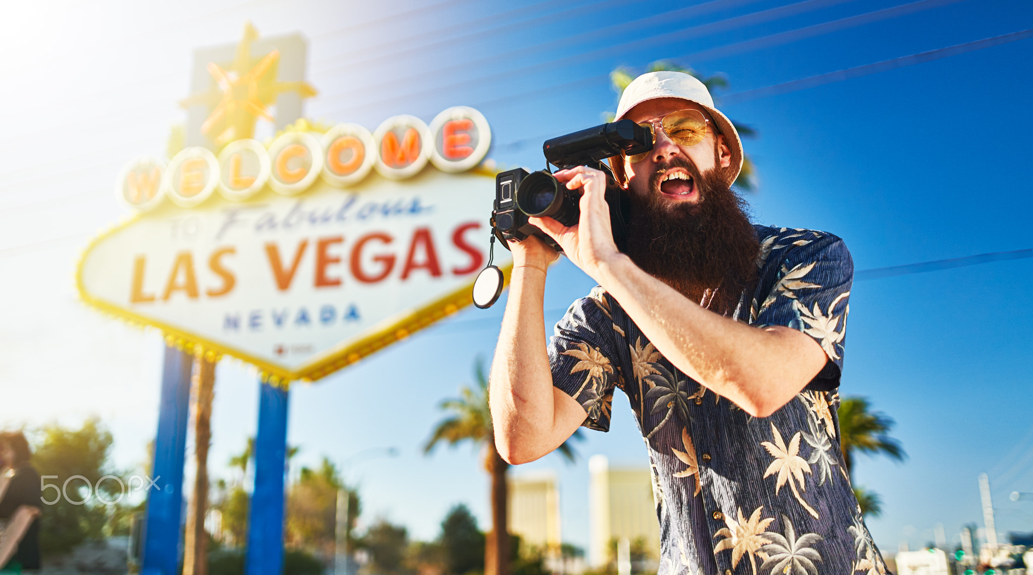 retro tourist in vegas with 80s camcorder in front of sign