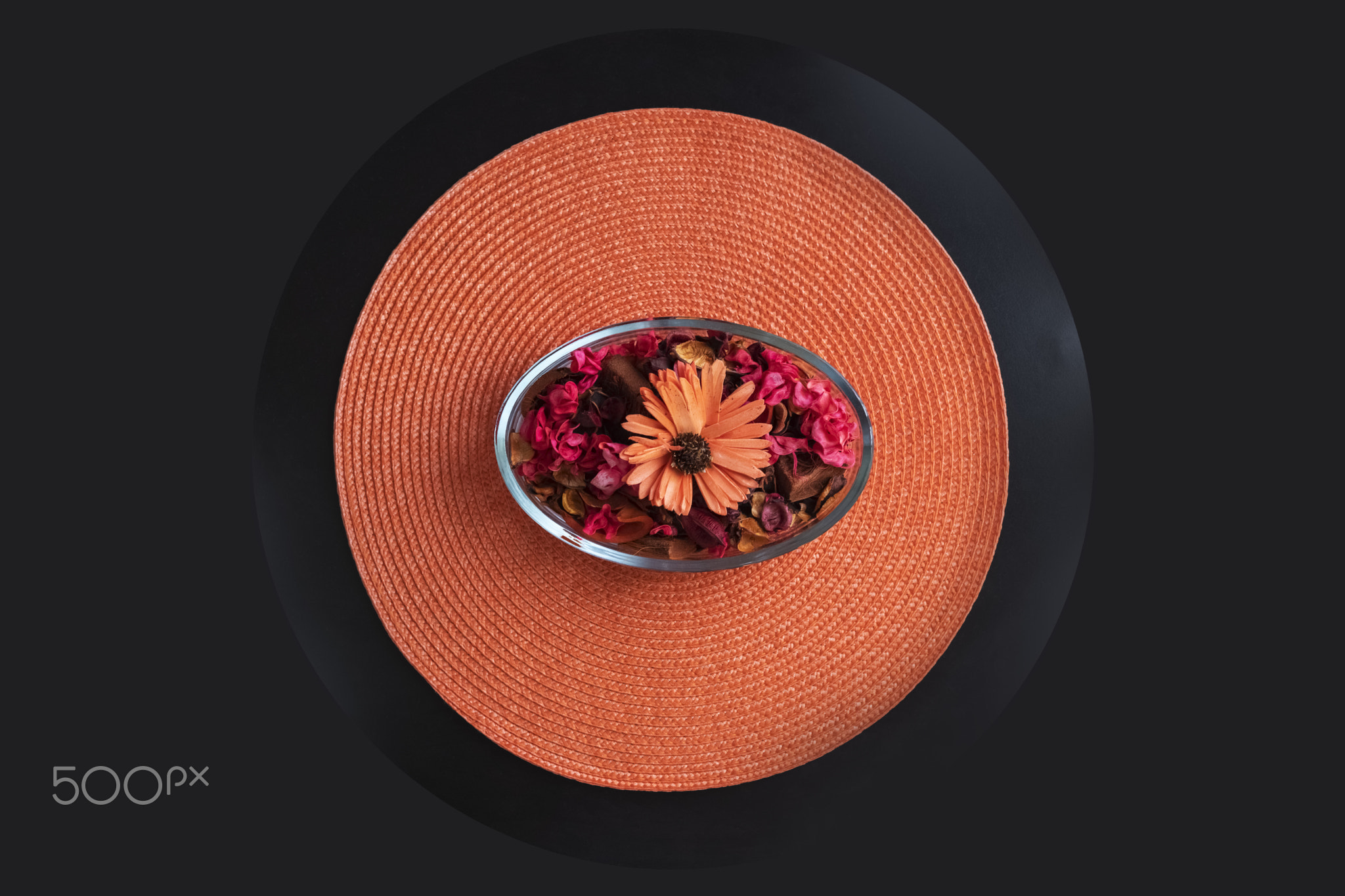 Dried petals flowers It is placed in a decorative bowl.on the orange mat