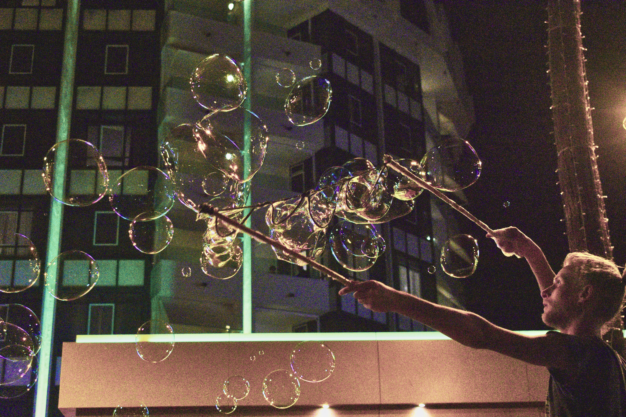 boy blowing bubbles at night