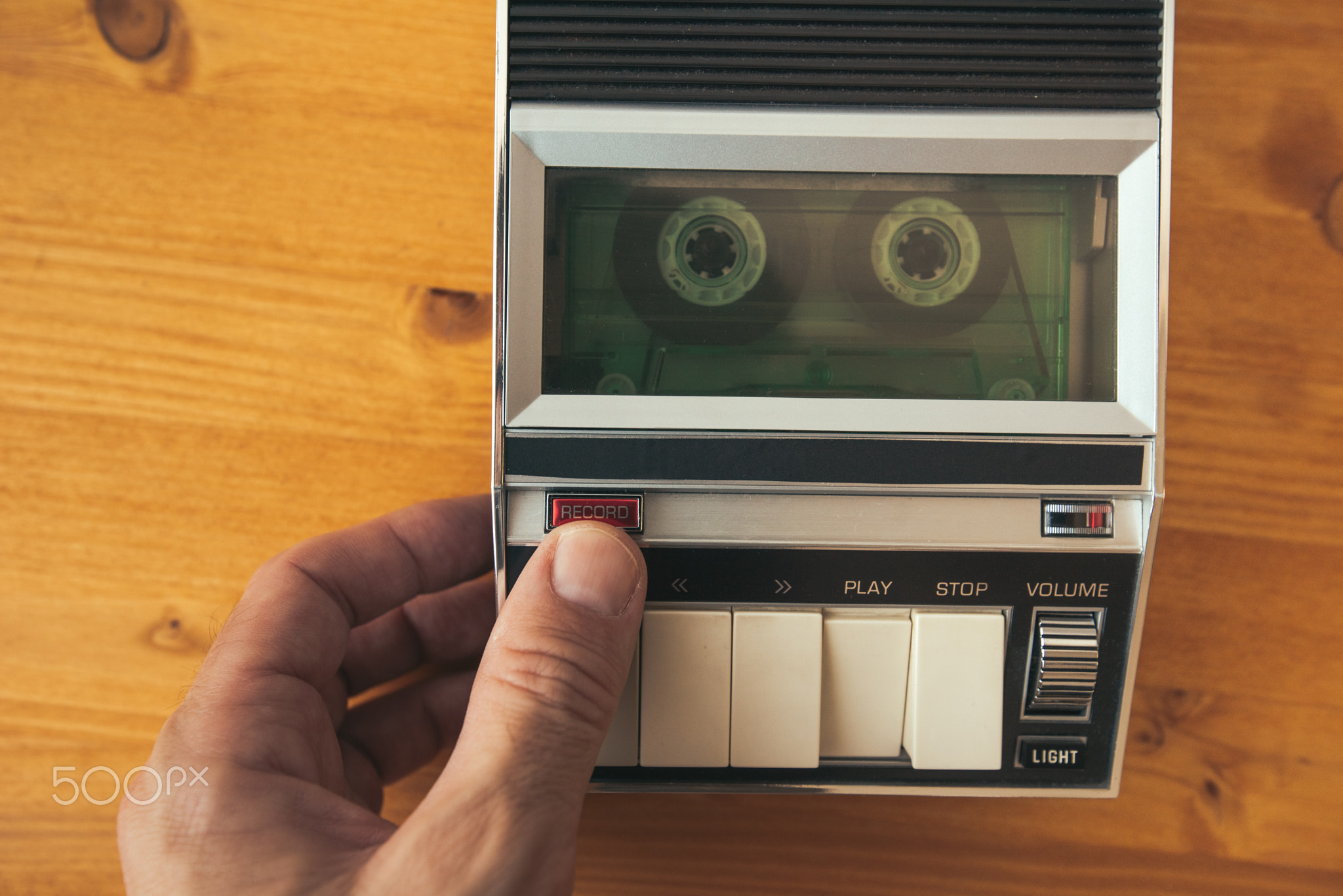 Finger pressing record button on vintage audio cassette tape pla