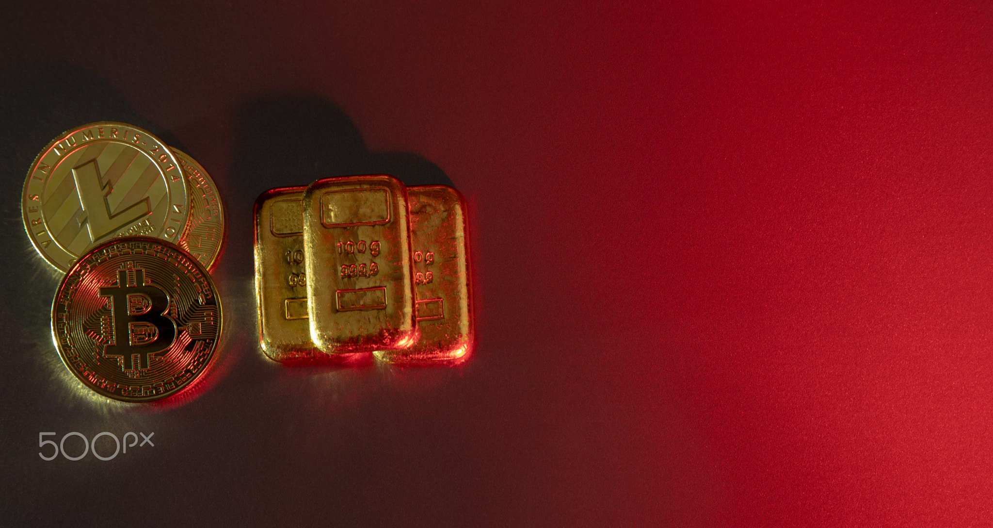 Gold bars and cryptocurrency coins on a red background. Current trends in financial markets.