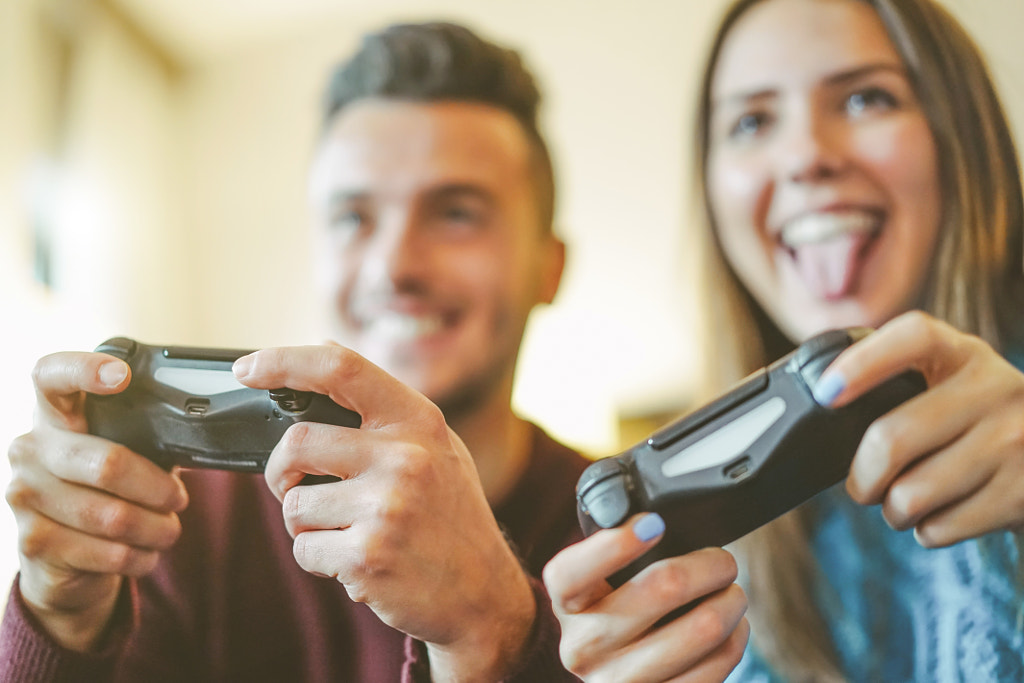 Happy friends playing video games in their apartment by Alessandro Biascioli on 500px.com