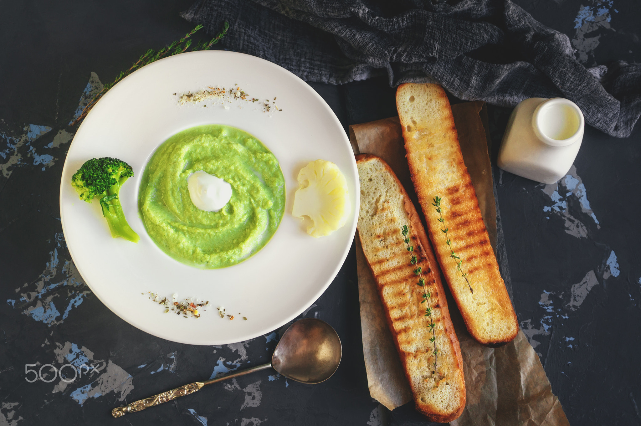 a bowl with vegetables puree on a white background. large white bowl with vegetable green cream soup