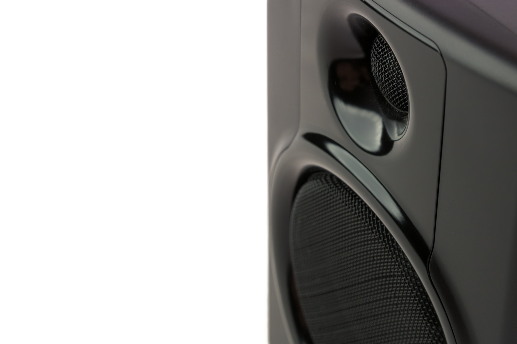 A close up  detail view of a studio speaker in front of a white