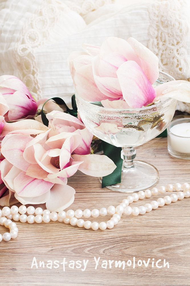 magnolia flowers with pearls on wooden table