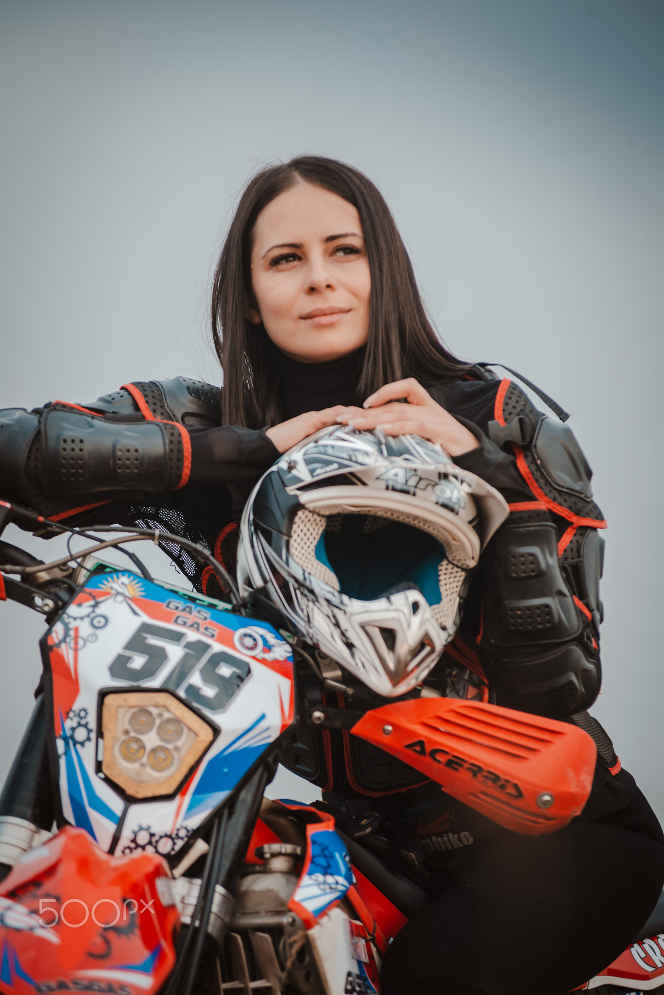 Beautiful brunette woman in motorcycle outfit. Female motocross racer next to her motorcycle Russia 
