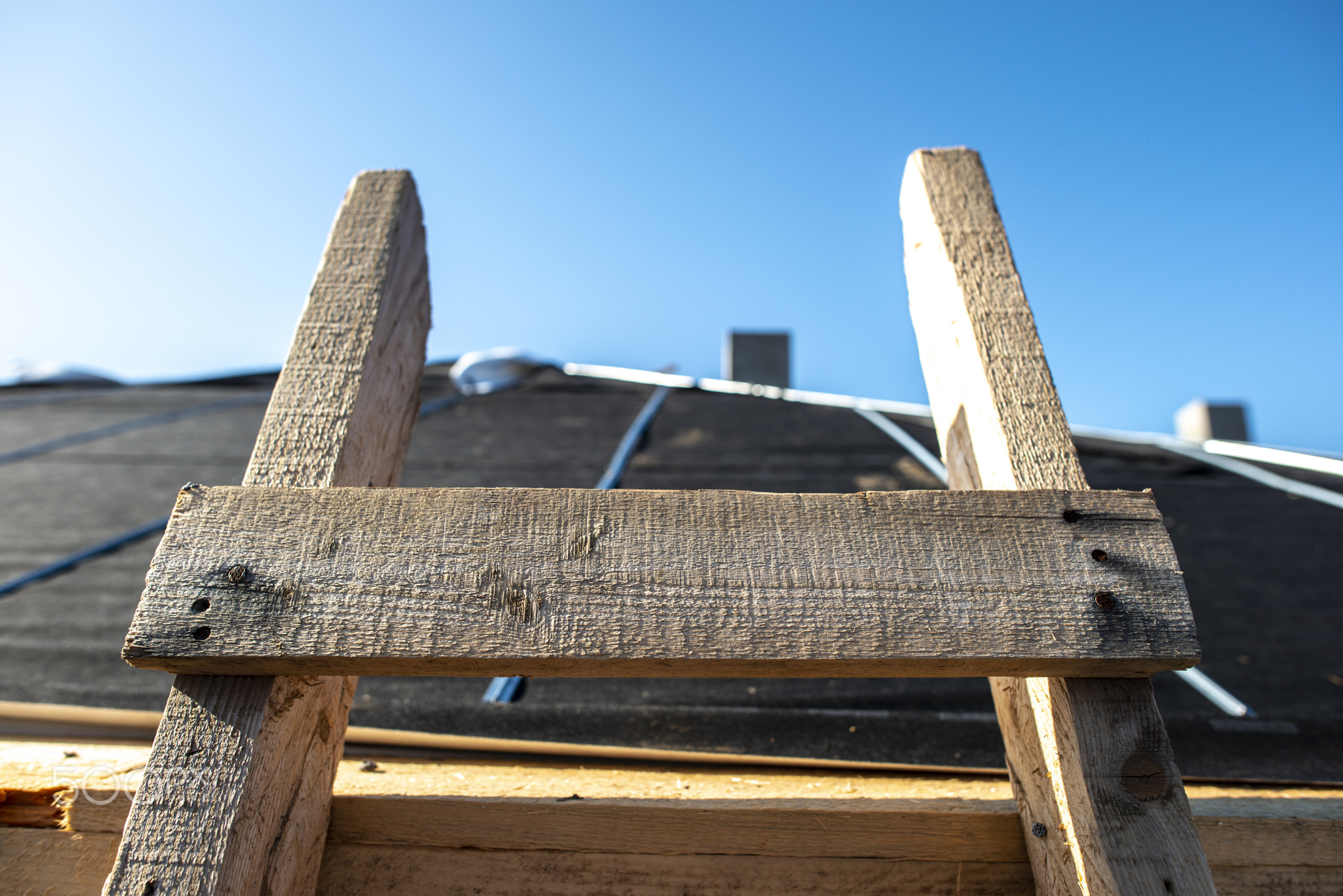 Wooden ladder on the roof of a house. Close-up wooden ladder.