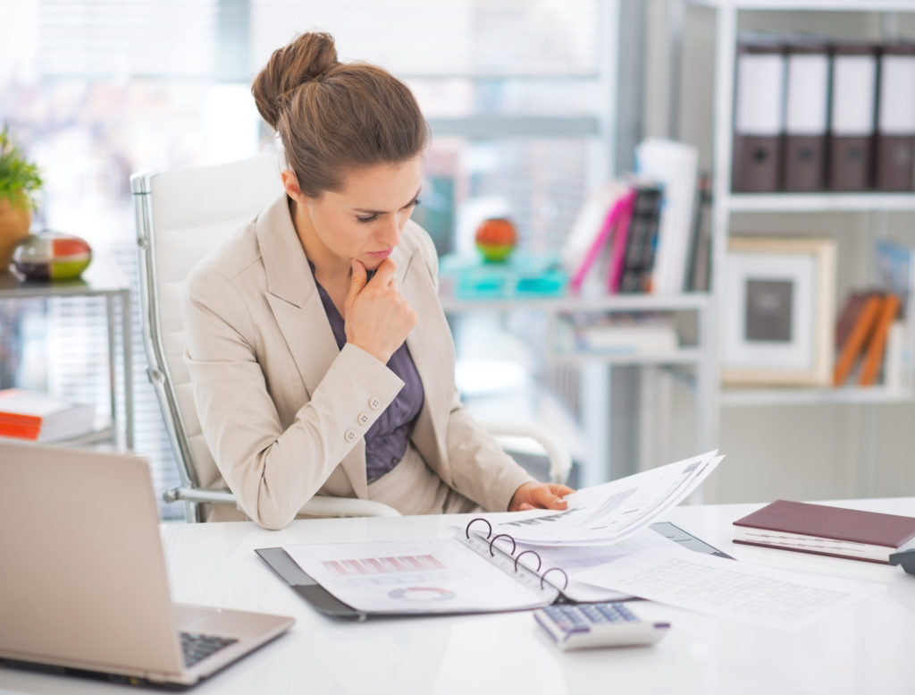 Thoughtful business woman documents in office