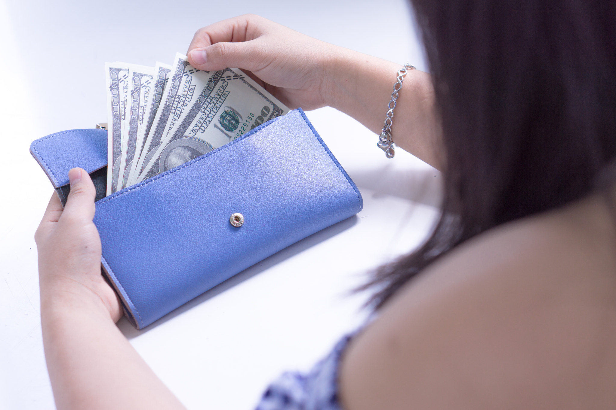 Woman hand taking out the money for payment from the blue wallet