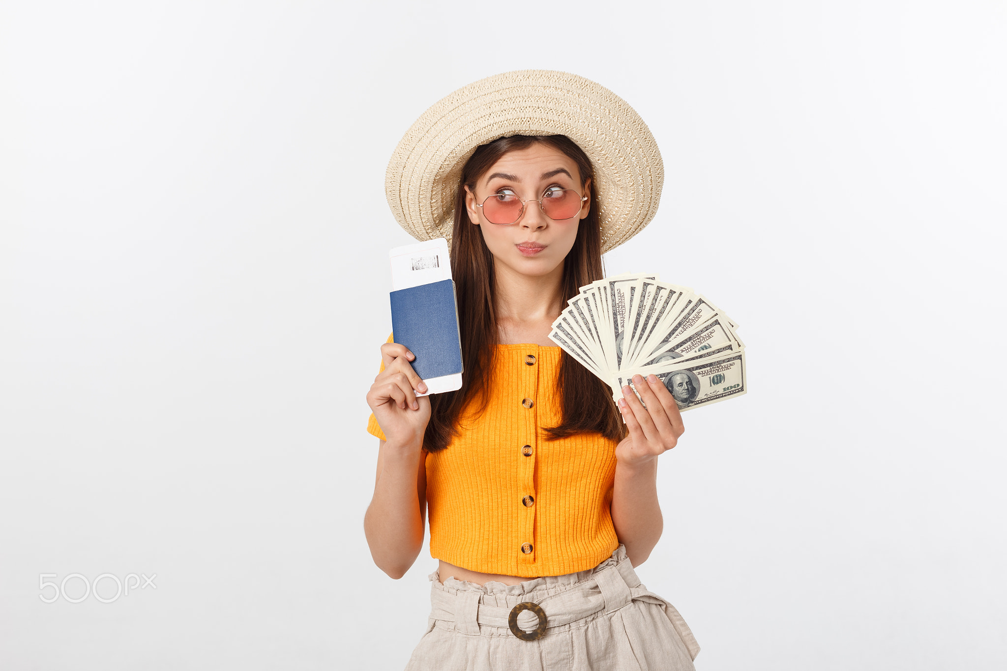 Portrait of cheerful, happy, laughing girl with hat on head, having money fan and passport with tick