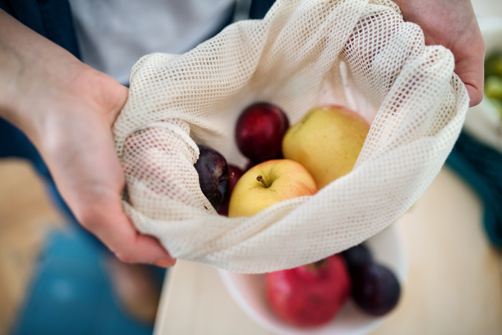 Midsection of woman holding fruit in reusable bag indoors, sustainable lifestyle. by Jozef Polc on 500px.com