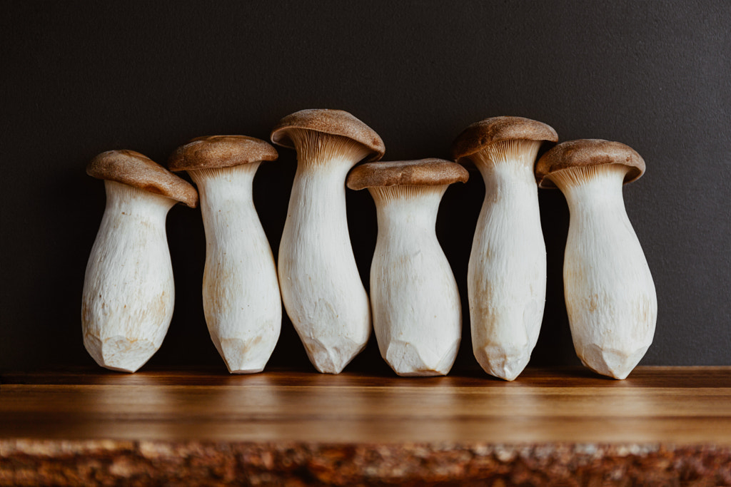 Group of raw King Oyster mushroom (also known as eryngii) on a wooden cutting kitchen board. by Edalin Photography on 500px.com