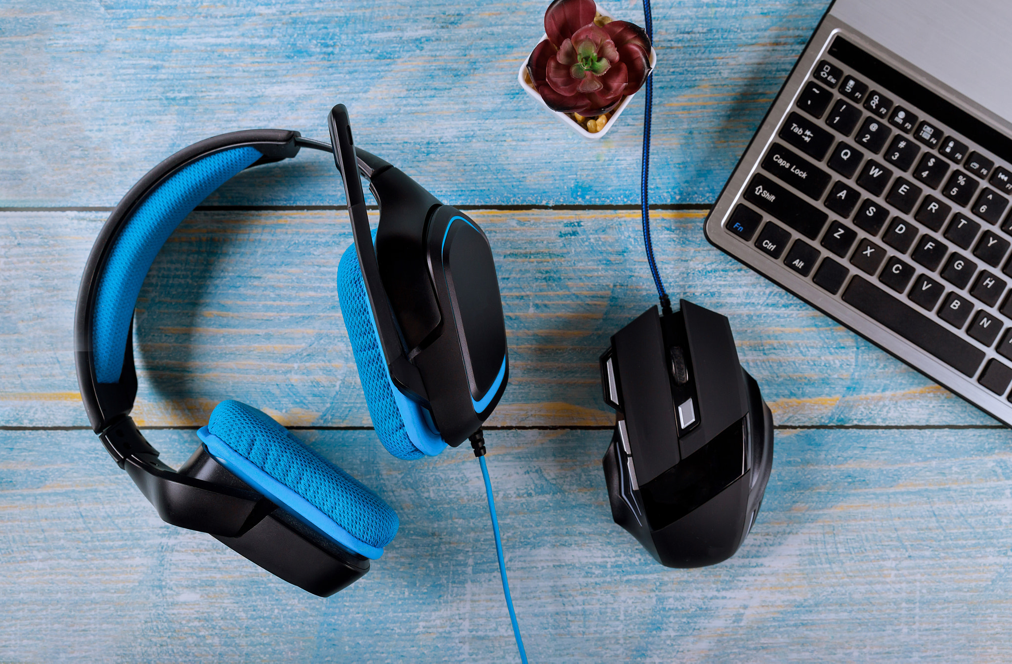 Computer gamer devices, modern mouse, headphones and keyboard with gaming accessories on table