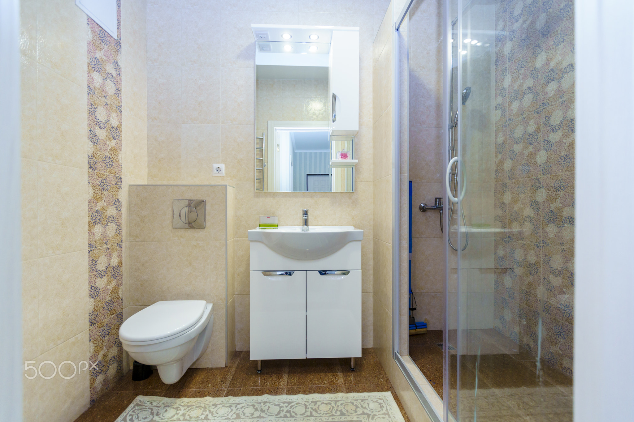Bathroom in the apartment. Shower, sink with mirror, toilet. Square