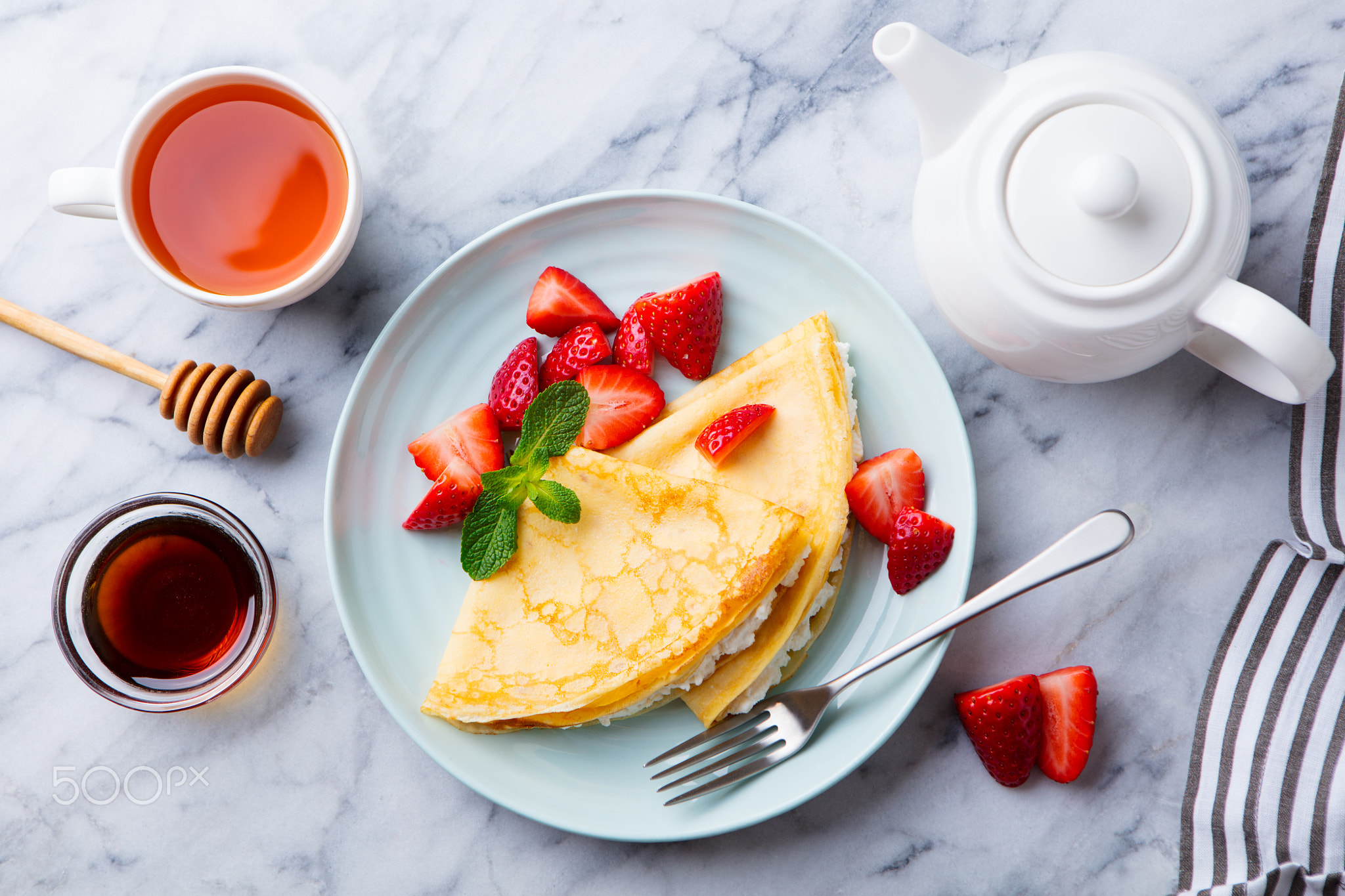 Crepes, thin pancakes with cream cheese, ricotta, fresh strawberries.