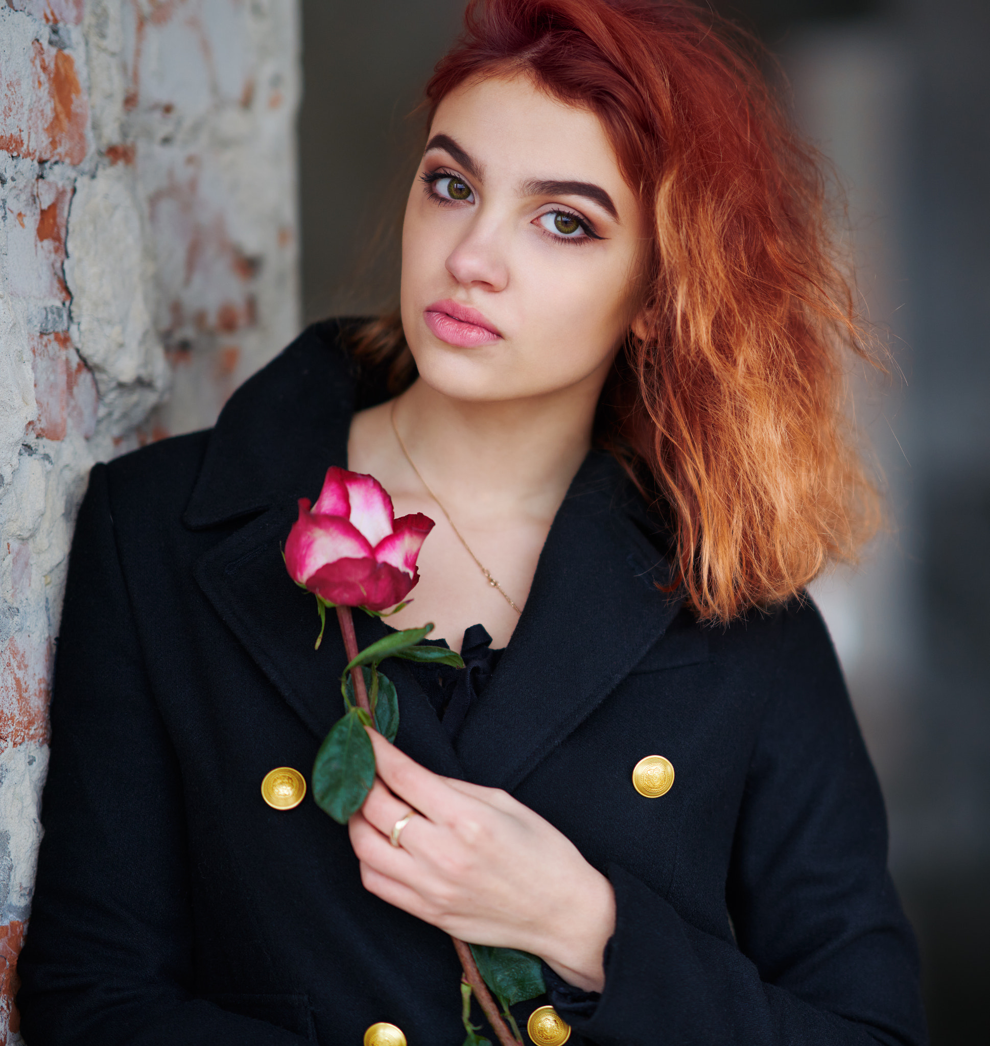 A lovely red-haired young girl in a black coat