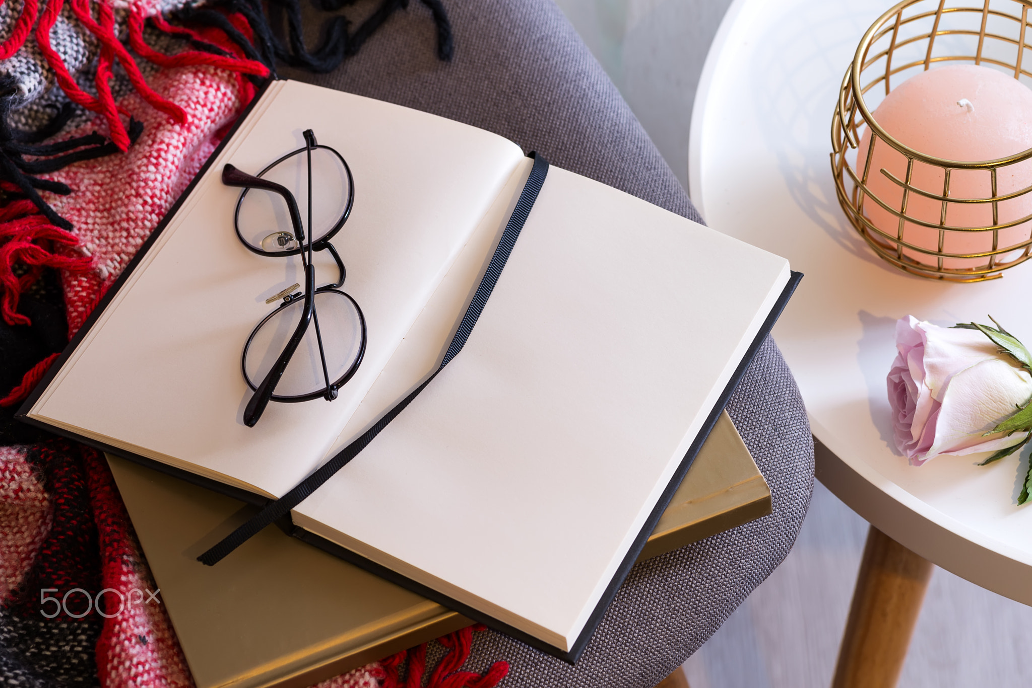 Notebook with glasses on a red plaid . Concept comfort.