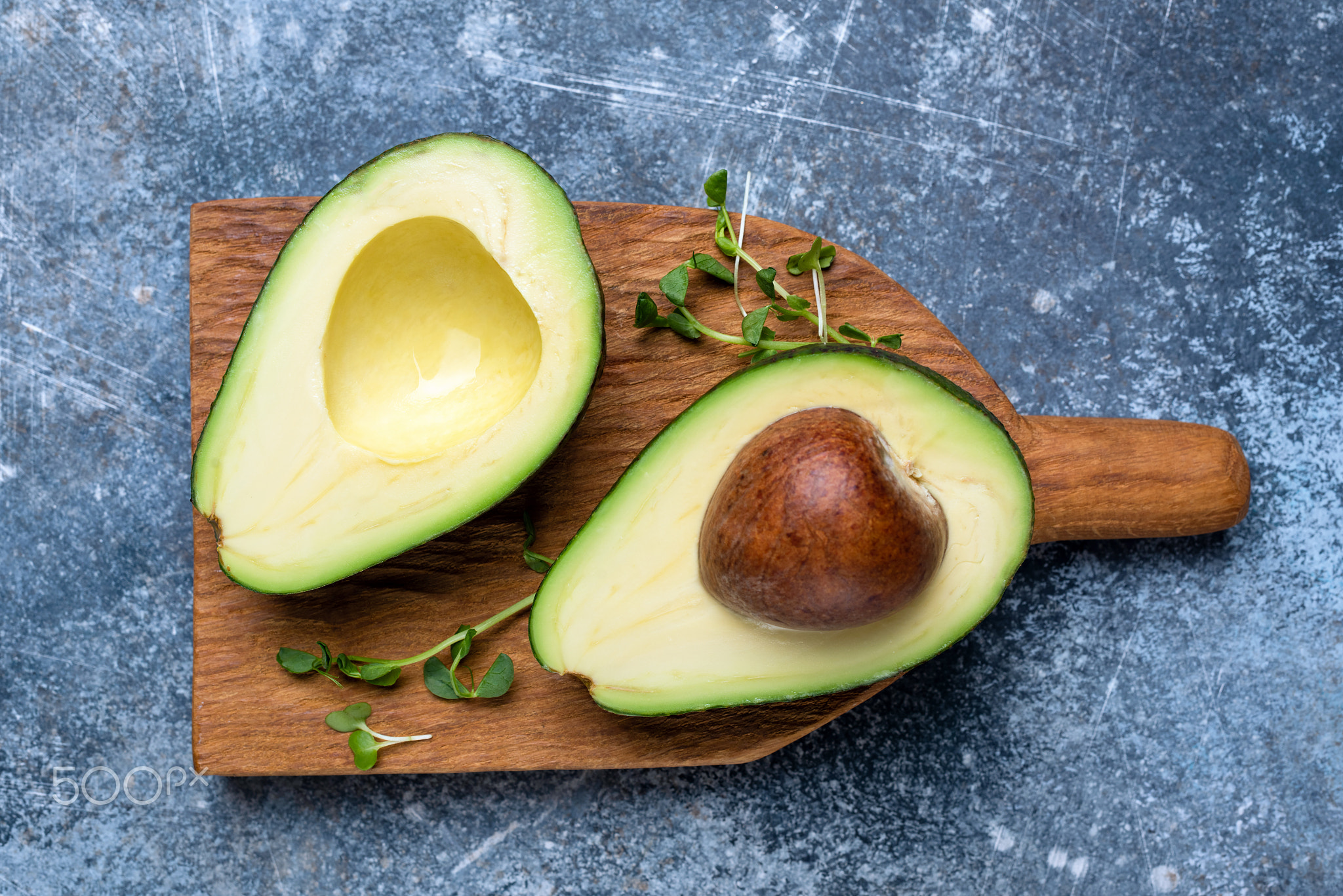 Halved avocado on a chopping board