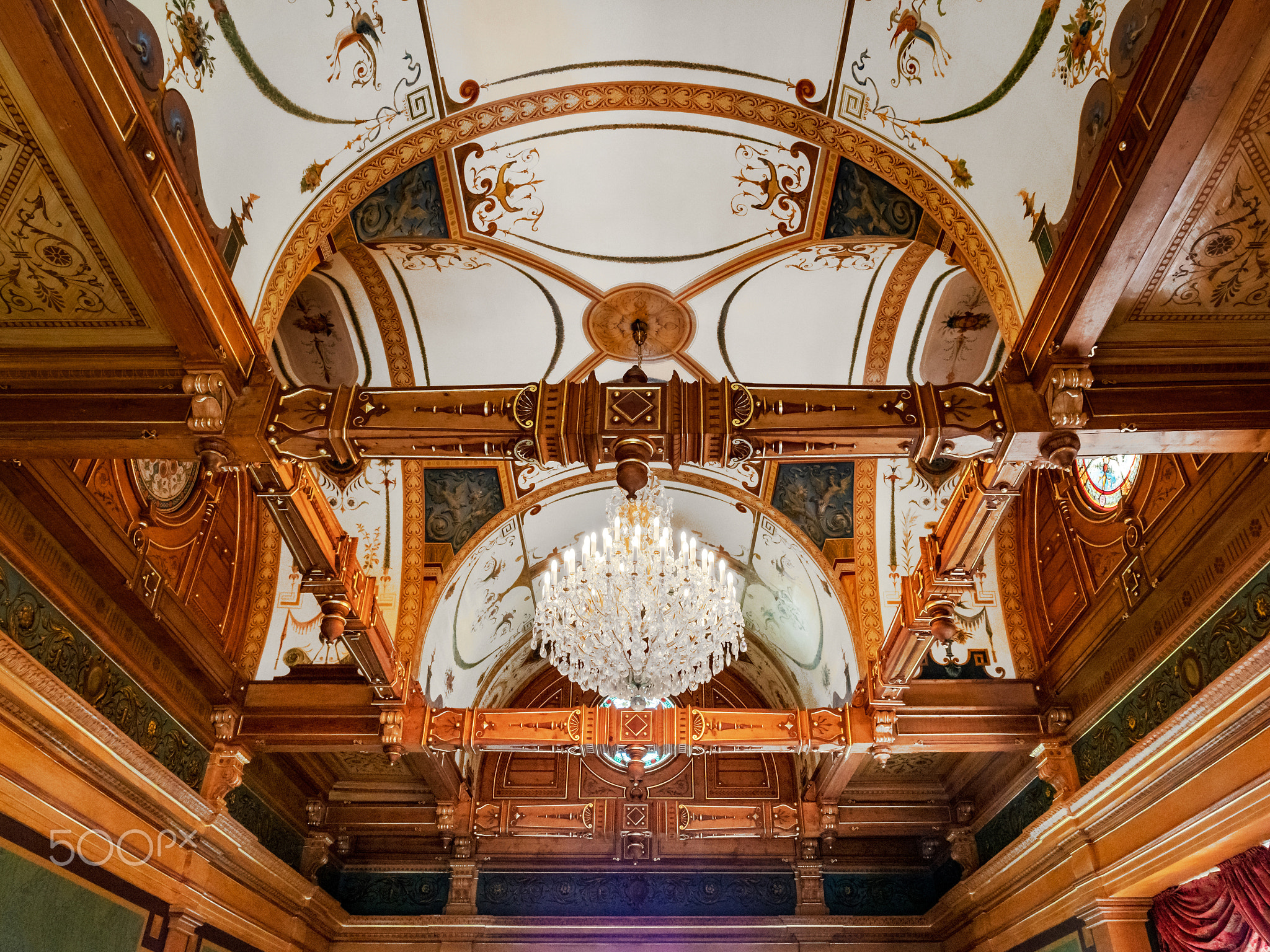 Gorgeous crystal round chandelier in an ornate old museum hall