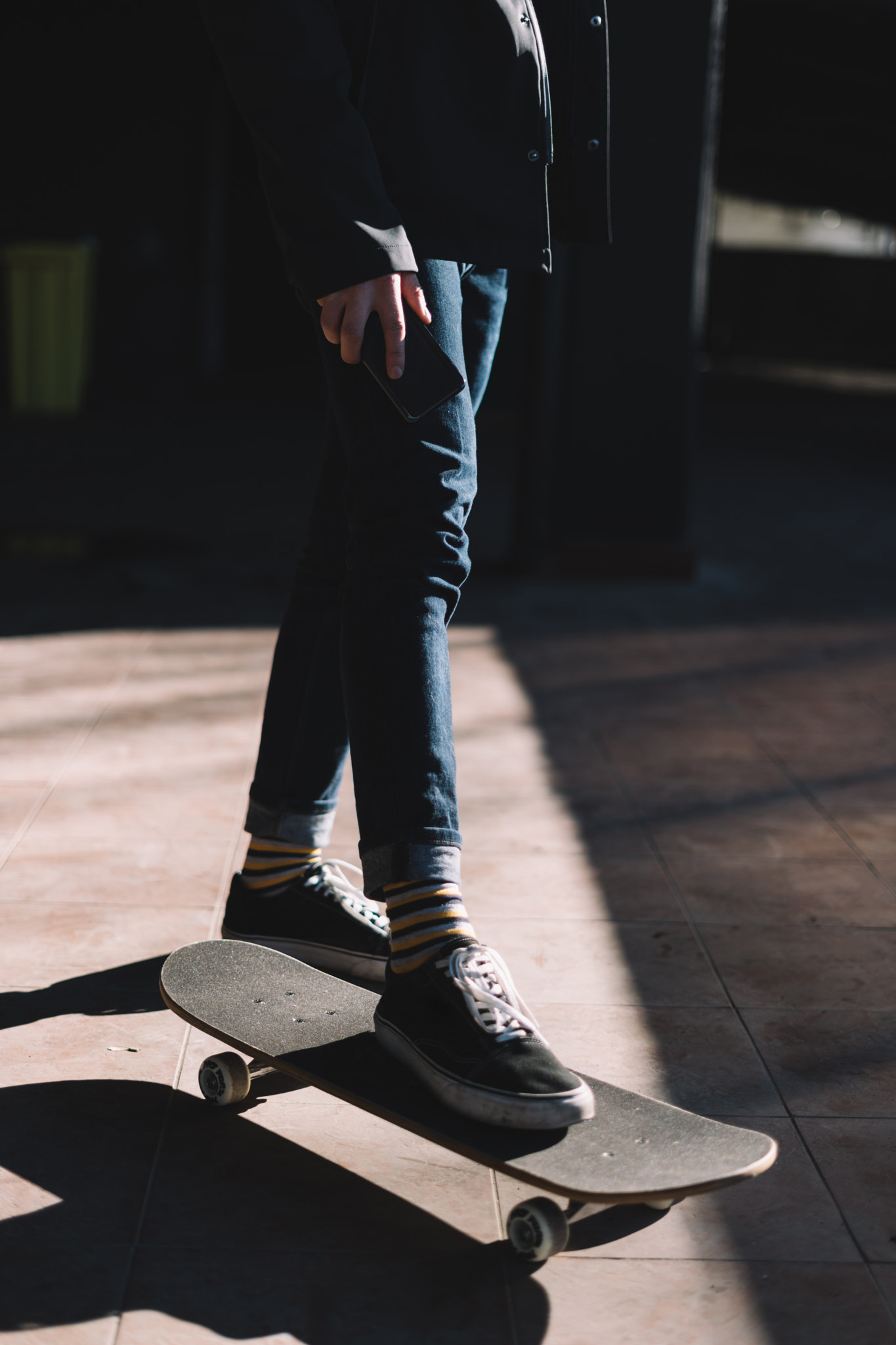 Young man on a skateboard holding a mobile phone