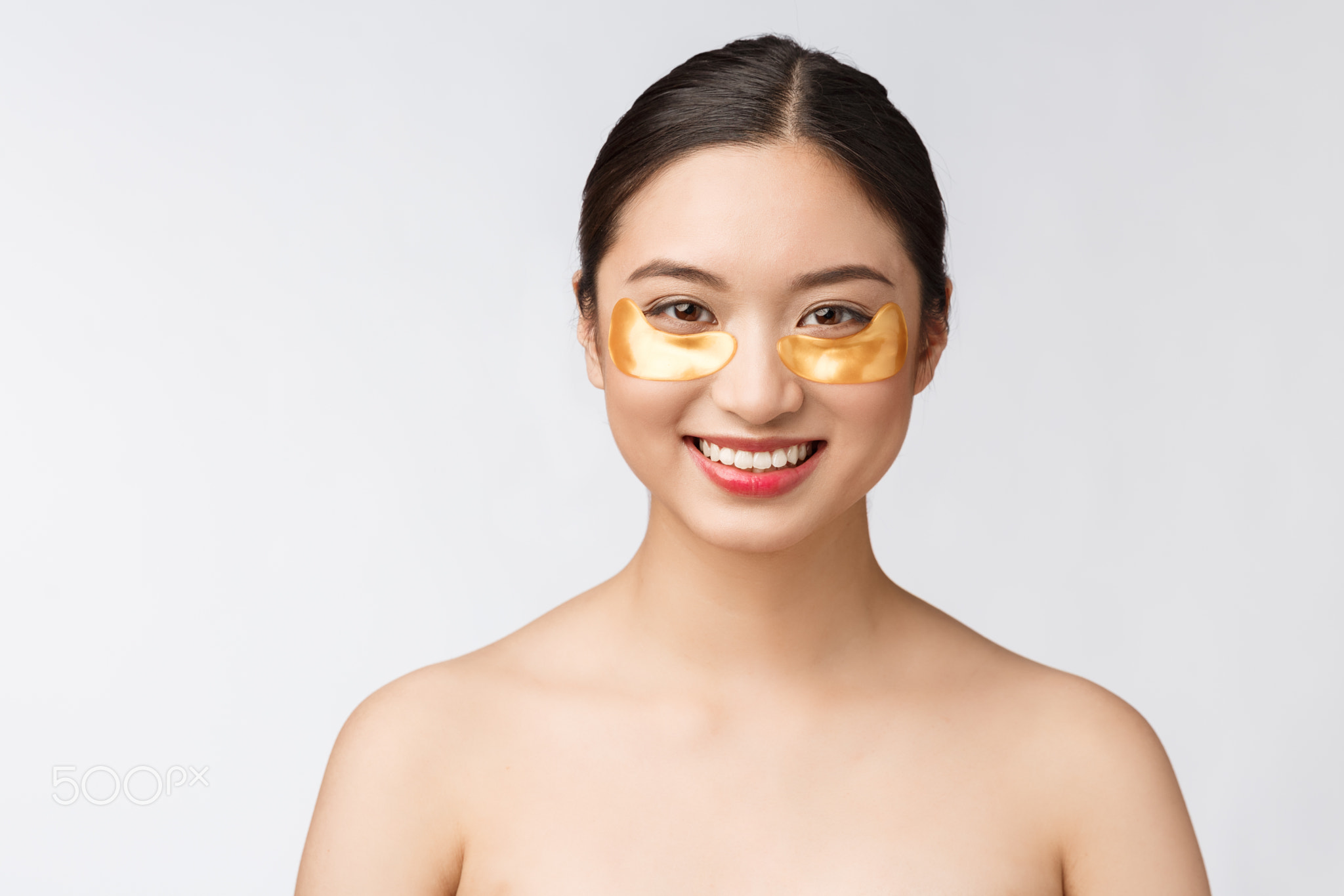 Asian beauty teenager woman care her skin with gold eye masks patches
