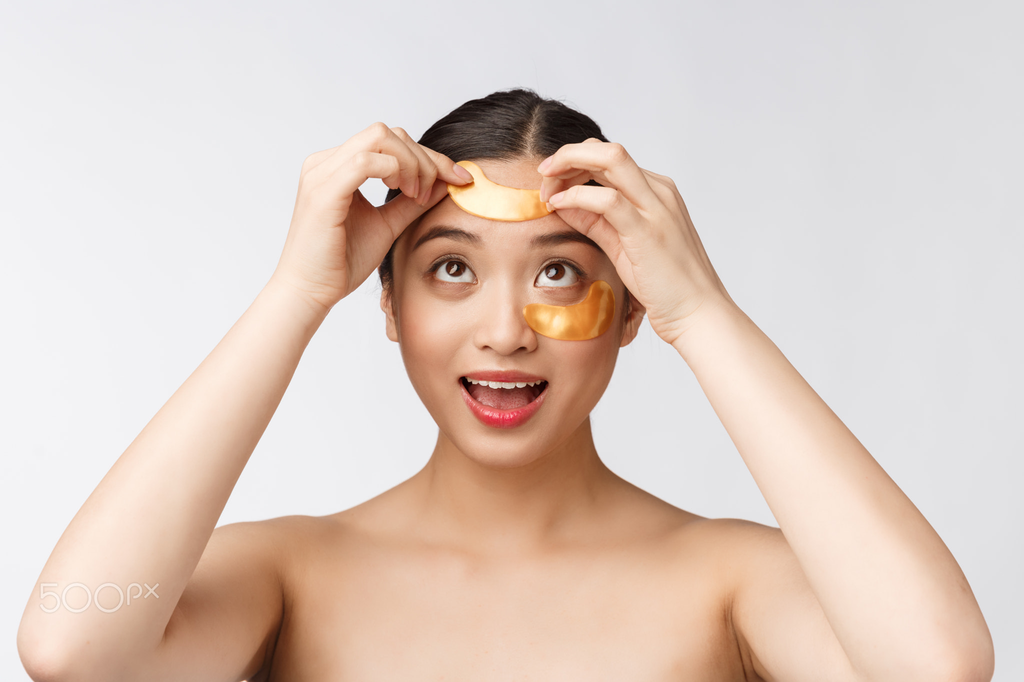 Asian beauty teenager woman care her skin with gold eye masks patches