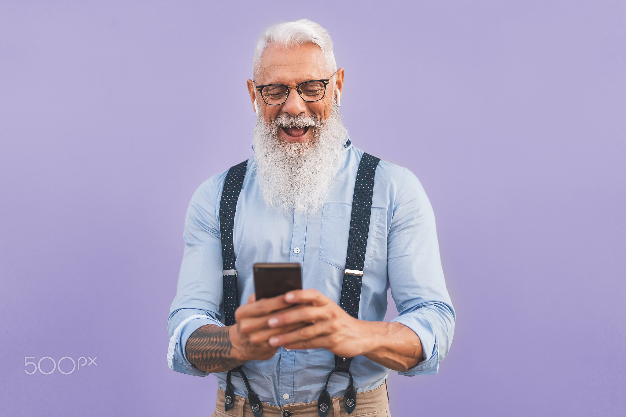 Senior man using mobile smartphone and listening music with airpods