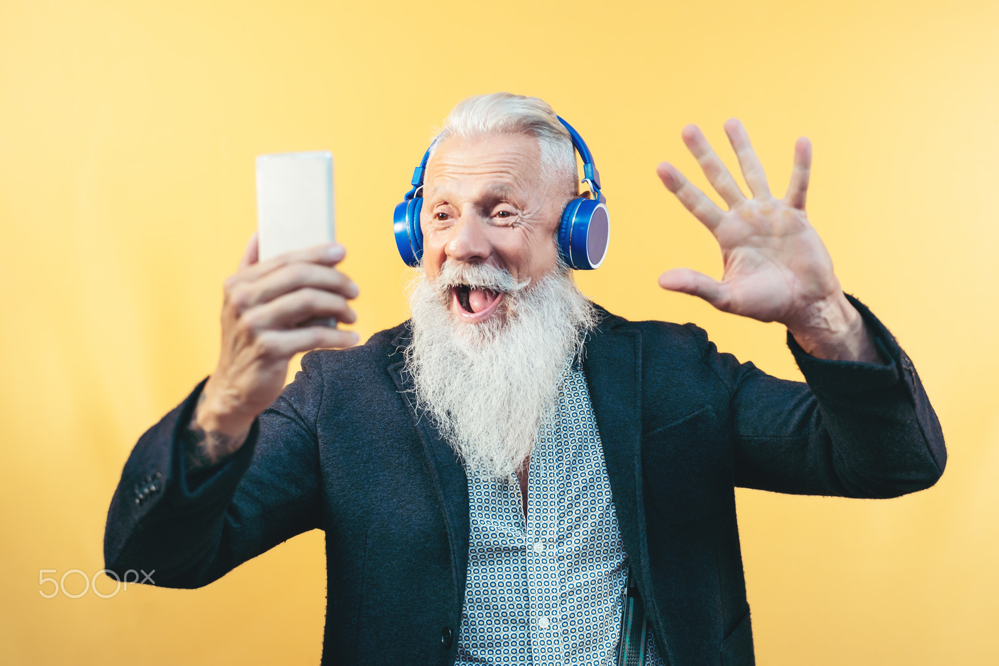 Happy senior man taking selfie while listening music with headphones