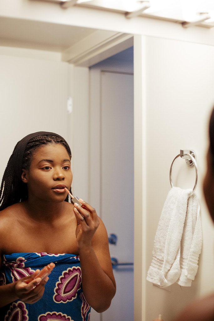 Young woman Applying Make-up in mirror, Delator 