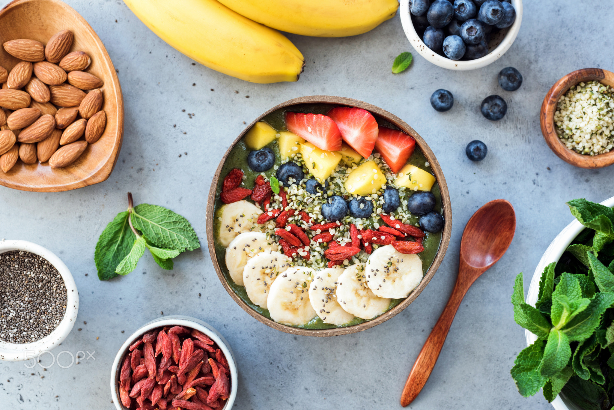 Raw green superfood smoothie bowl with toppings