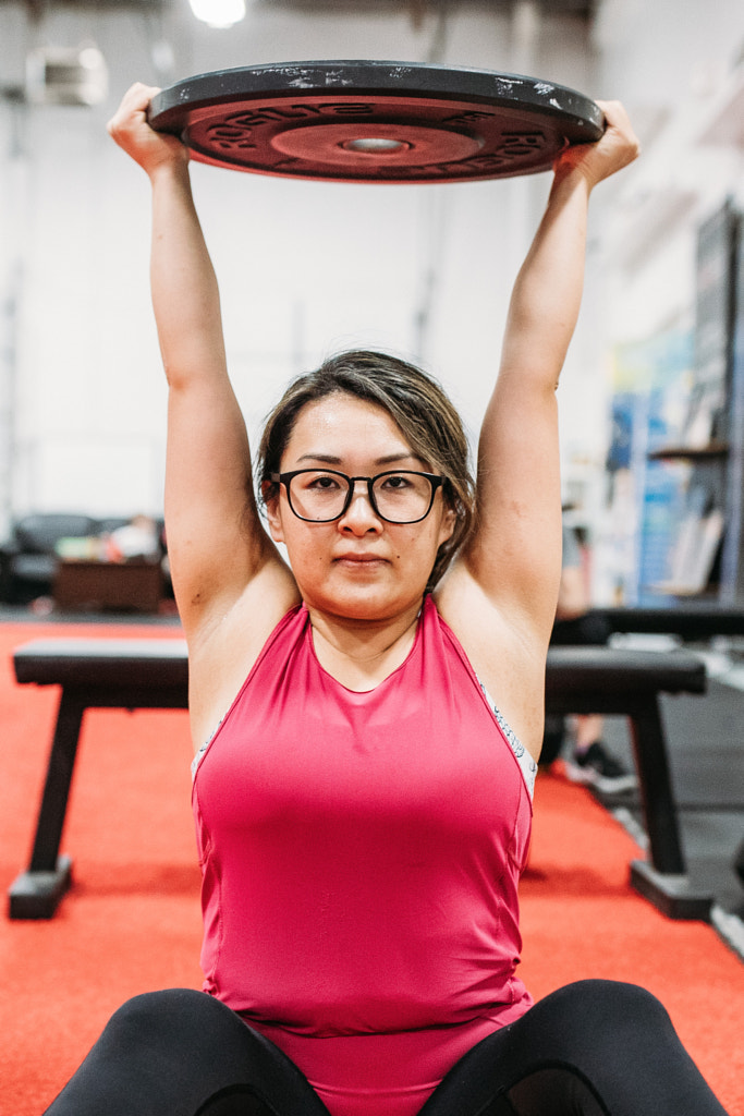 Asian female weightlifter showing daughter how to lift, Sharlene by Winnie Bruce on 500px.com