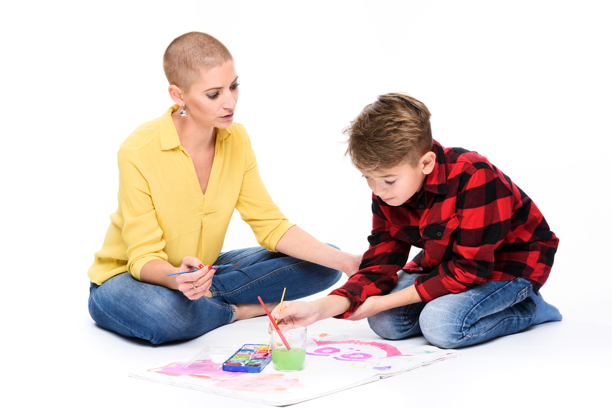 Boy and therapist in occupational therapy painting with watercolors.