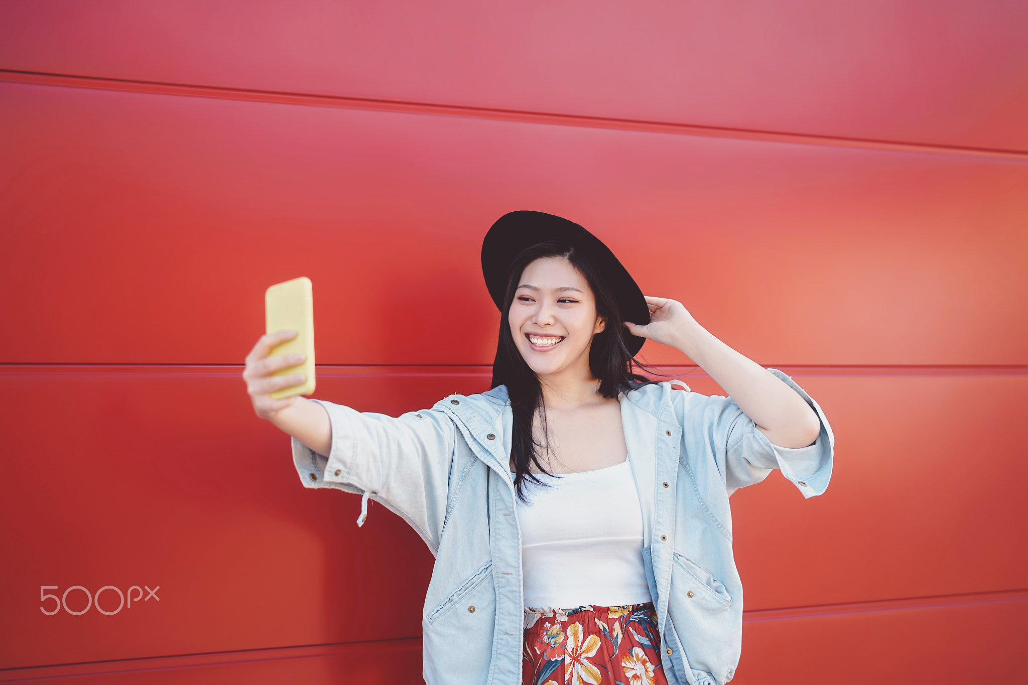 Happy Asian girl taking selfie with mobile smart phone outdoor