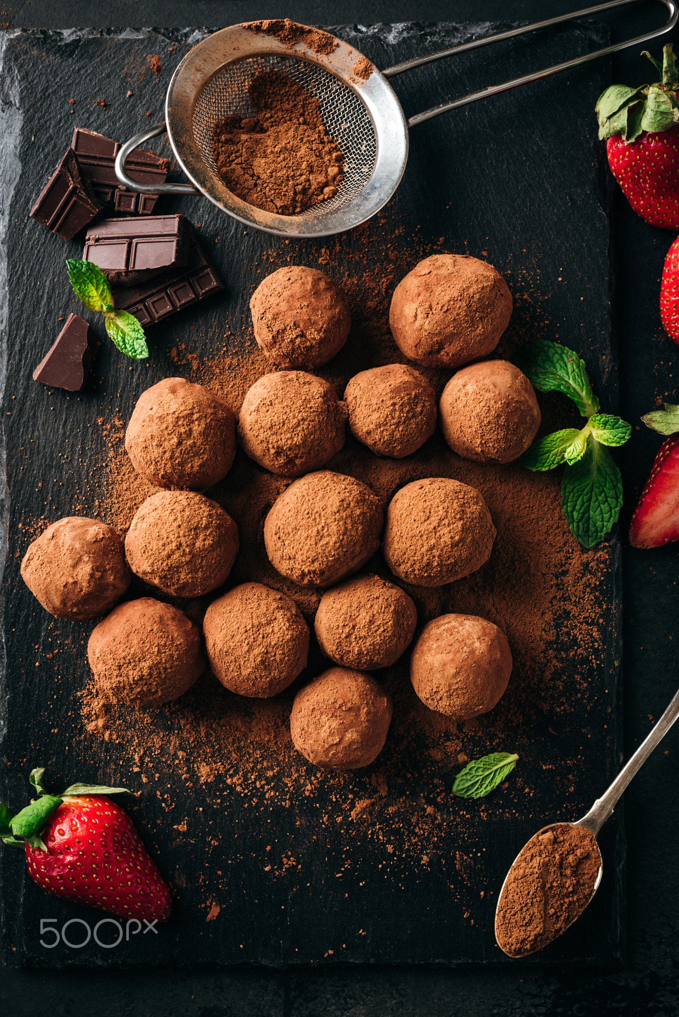 Chocolate truffles on black slate background